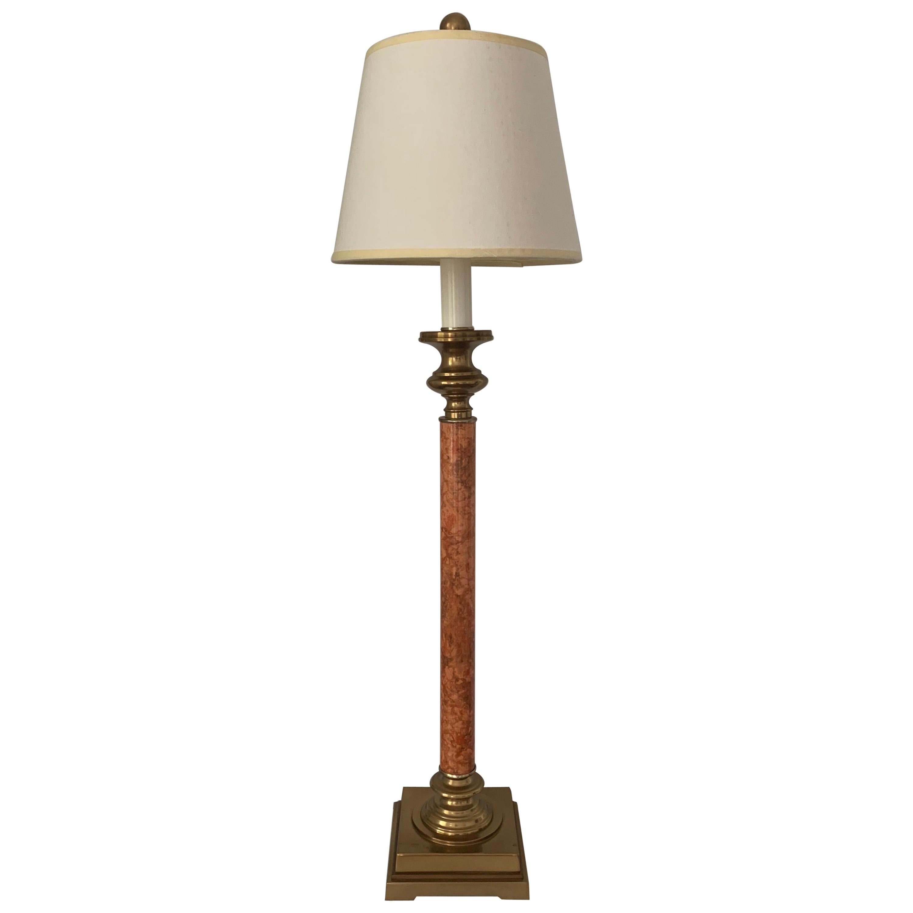 A tall brass candlestick table lamp with marbleized stem. Accented by a brass ball-shaped finial. Unmarked, possibly by Chapman. 

Takes 2 standard US bulbs, 60
watts max each. On/off switch on cord. 

Includes off-white linen