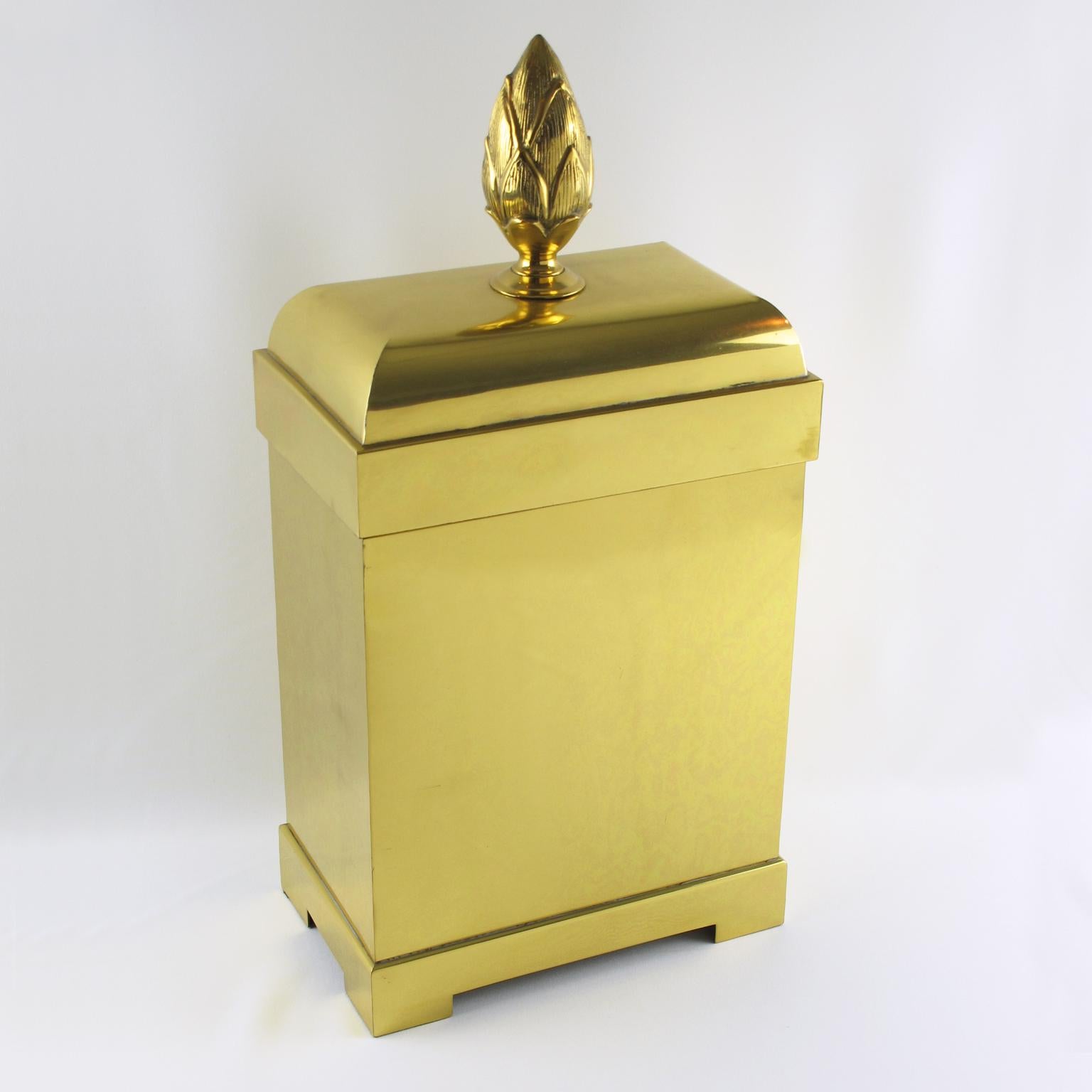 Chapman Manufacturing Company designed this stunning, oversized lidded brass decorative box or magazine storage stand in the 1980s. The box boasts a tall geometric shape and a massive brass pine cone-carved handle. The piece is lined with a black