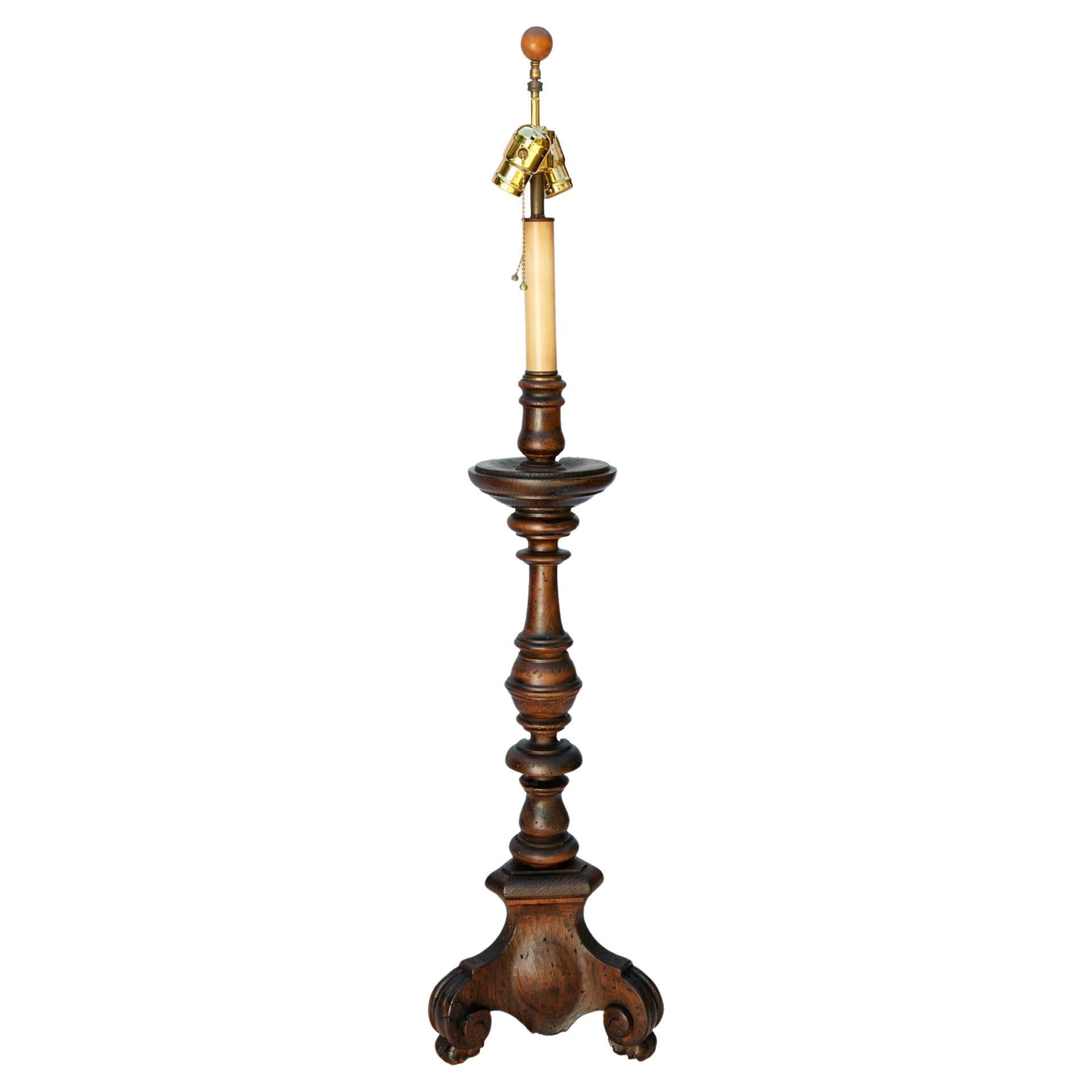 Hand carved candlestick lamp by Chapman Manufacturing company with dark  walnut finish. Polished brass lamp works providing directional lighting with two light sources.
New linen shade is included.