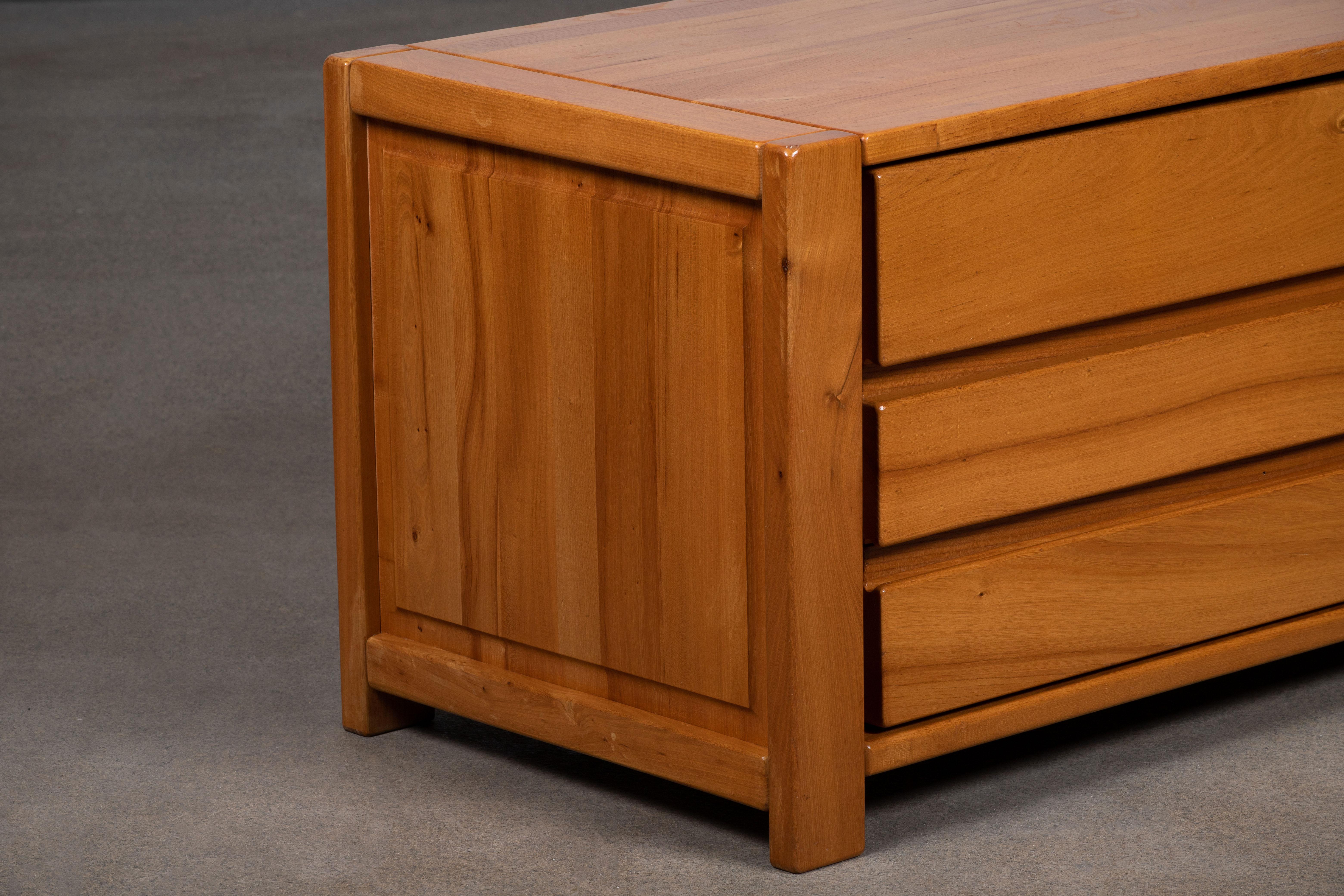 Este impresionante aparador se atribuye a Maison Regain, Francia, a finales de la década de 1970. El aparador está fabricado en madera de olmo maciza y tiene una puerta doble a la izquierda con dos tiradores escultóricos de bella factura. 
Las