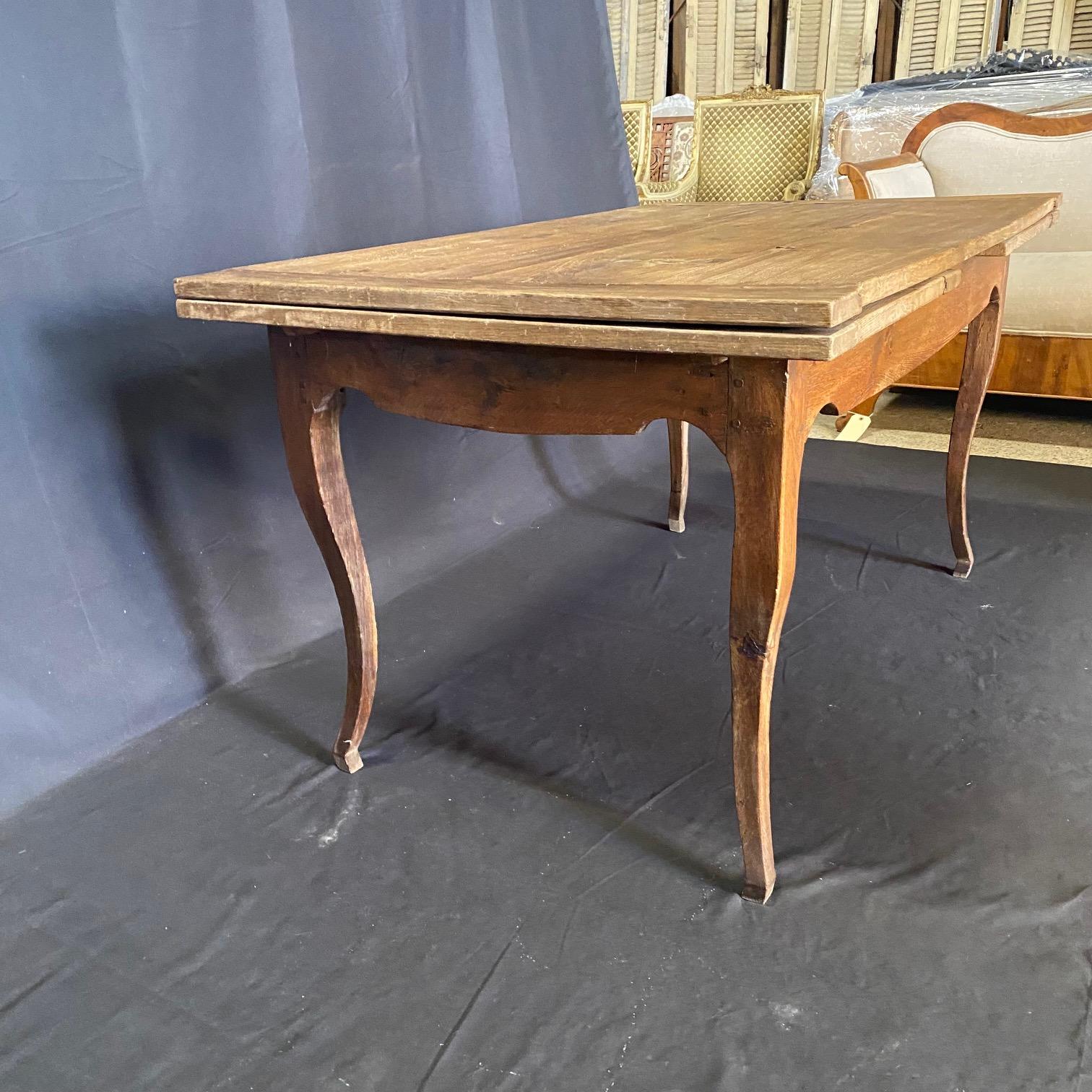 Table de salle à manger en chêne massif de style provincial français du XIXe siècle, achetée dans le sud de la France, avec un joli tablier aux formes sculpturales sur des pieds cabriole effilés, dégageant un charme vibrant et robuste.