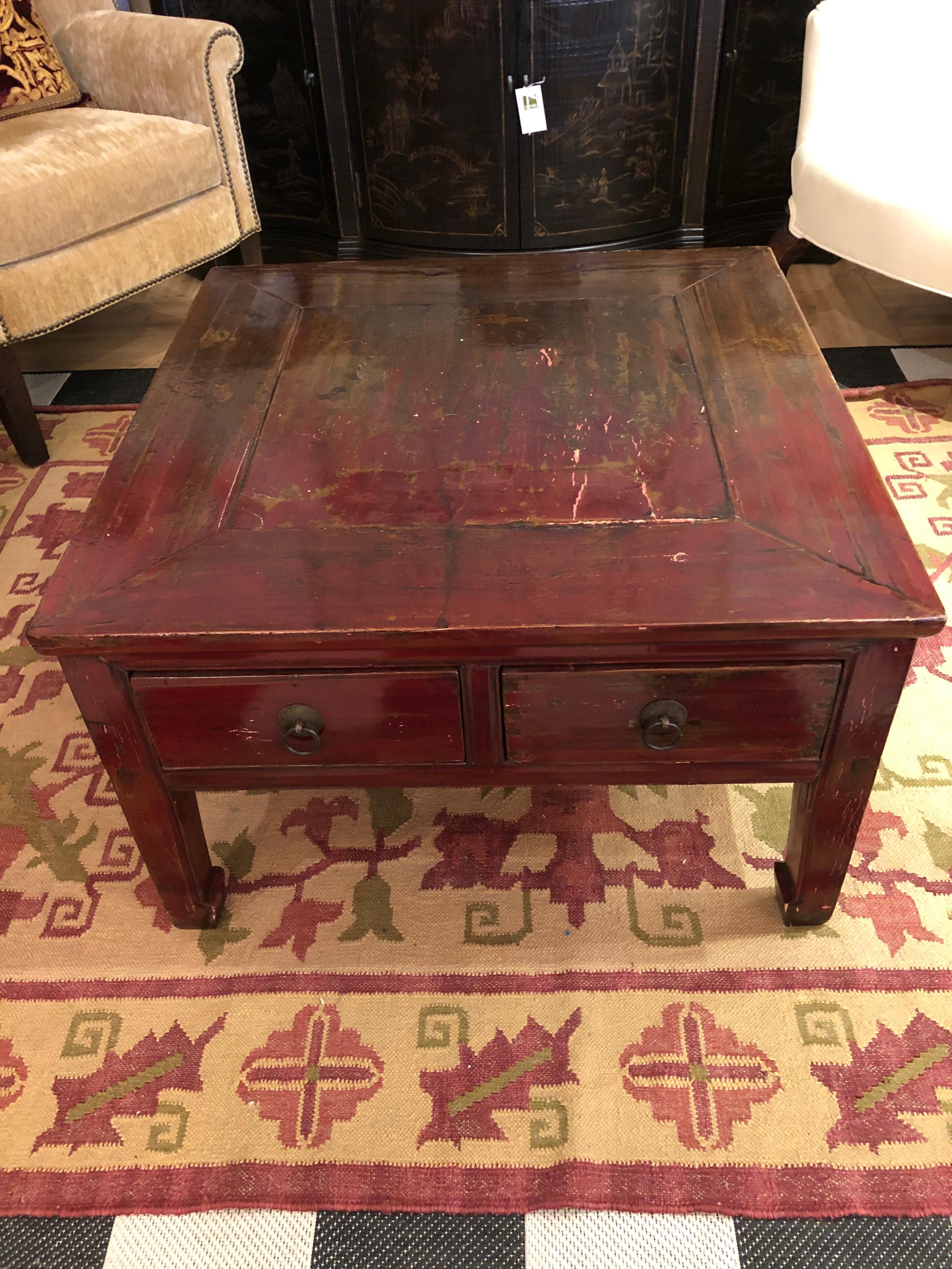 Luscious deep red color and fantastic distressed aged patina make this Asian style coffee table a stand out. The square shape adds a great anchor to a room, and there are 2 drawers on front and back, so very functional as well. A great spot to park