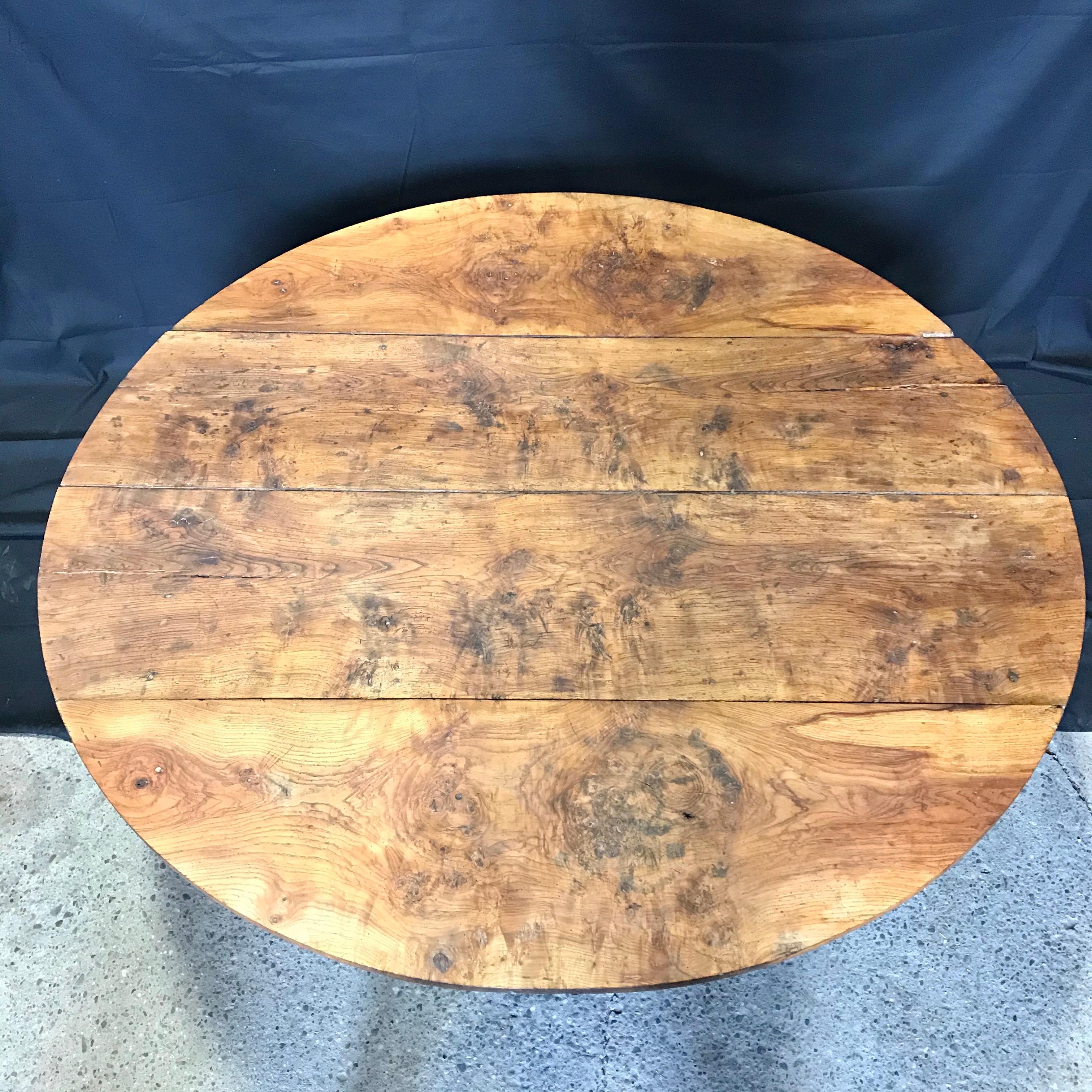 A wonderful distressed antique elm dining table with two drop leaves. When open the table is round. Lovely turned legs and lively grain give French country flavor and character. 
#5189
 
H skirt 23.75”.
  