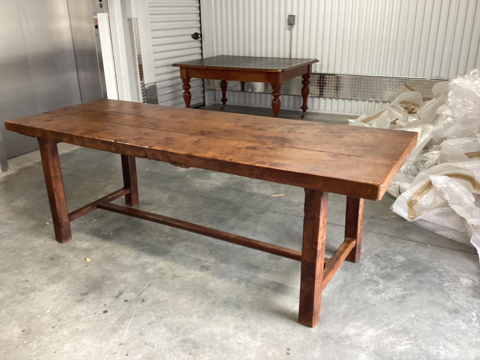 Purchased in Normandy, France, this 19th century farm table has amazing character with knotted elm wood, warm diverse colors and authentic signs of age. Massive full wood boards make up the top that rests on 4 simple straight legs and a cross