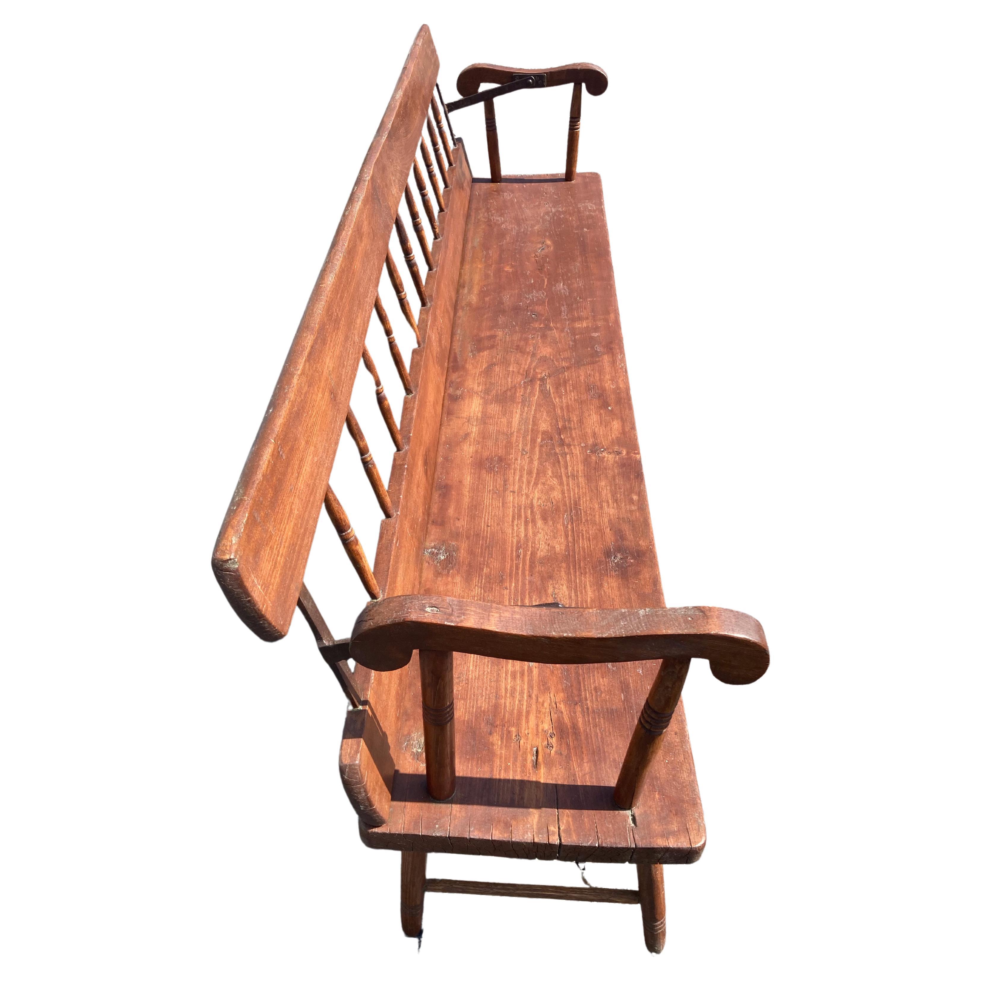 A beautifully designed 19th century pine very large bench having a spindle back that flips one one side to the other, so bench can be used in either direction. Was probably used in an American meeting house.
Measures: Arm height 27.