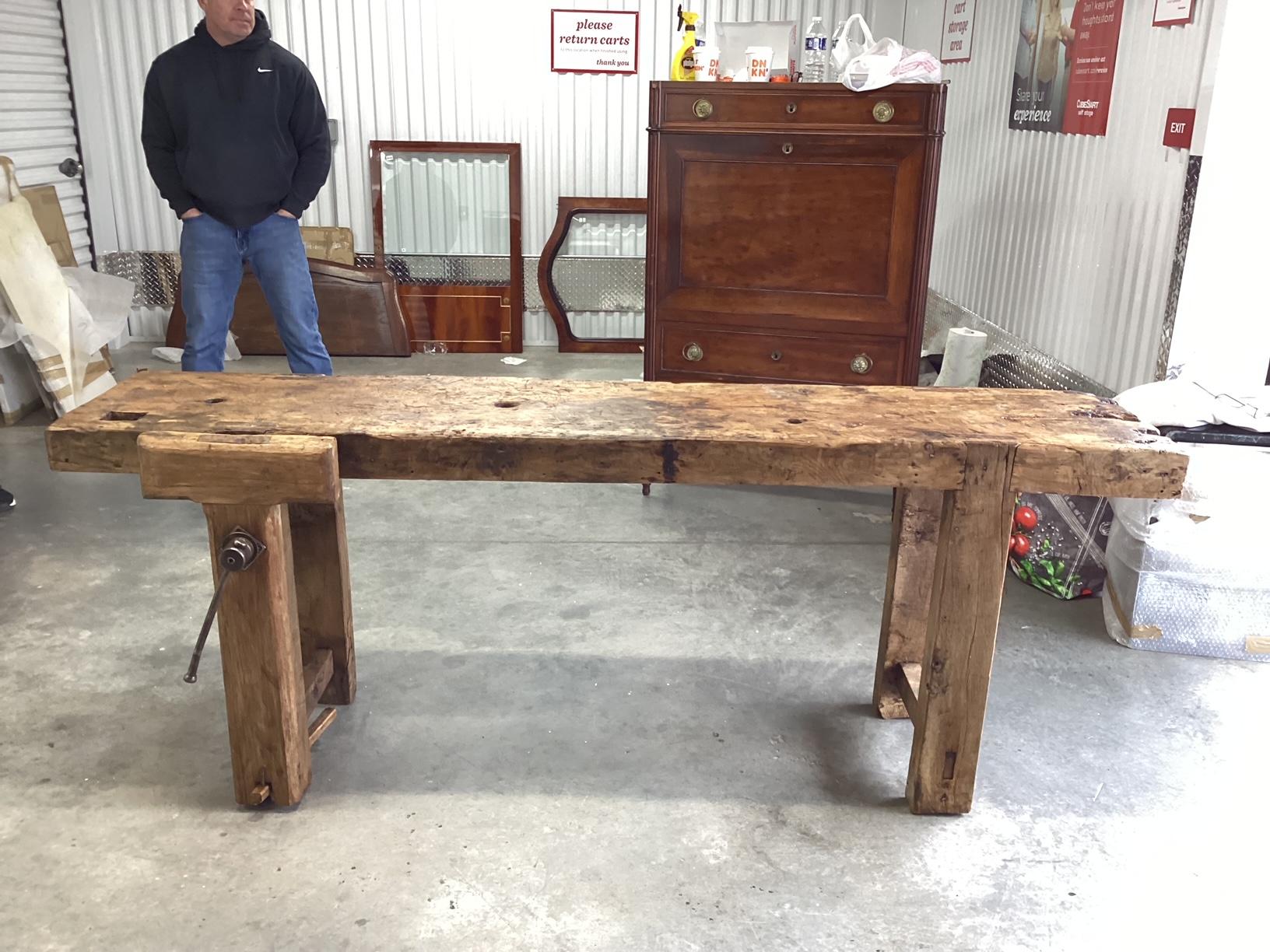 This is one incredibly aged and unique French work bench. Dating to the 1800's, this work bench is made of knotted elm and features a thick plank top over 4 rough hand hewn legs. You will find holes in the top for tools and an authentic vise. Given
