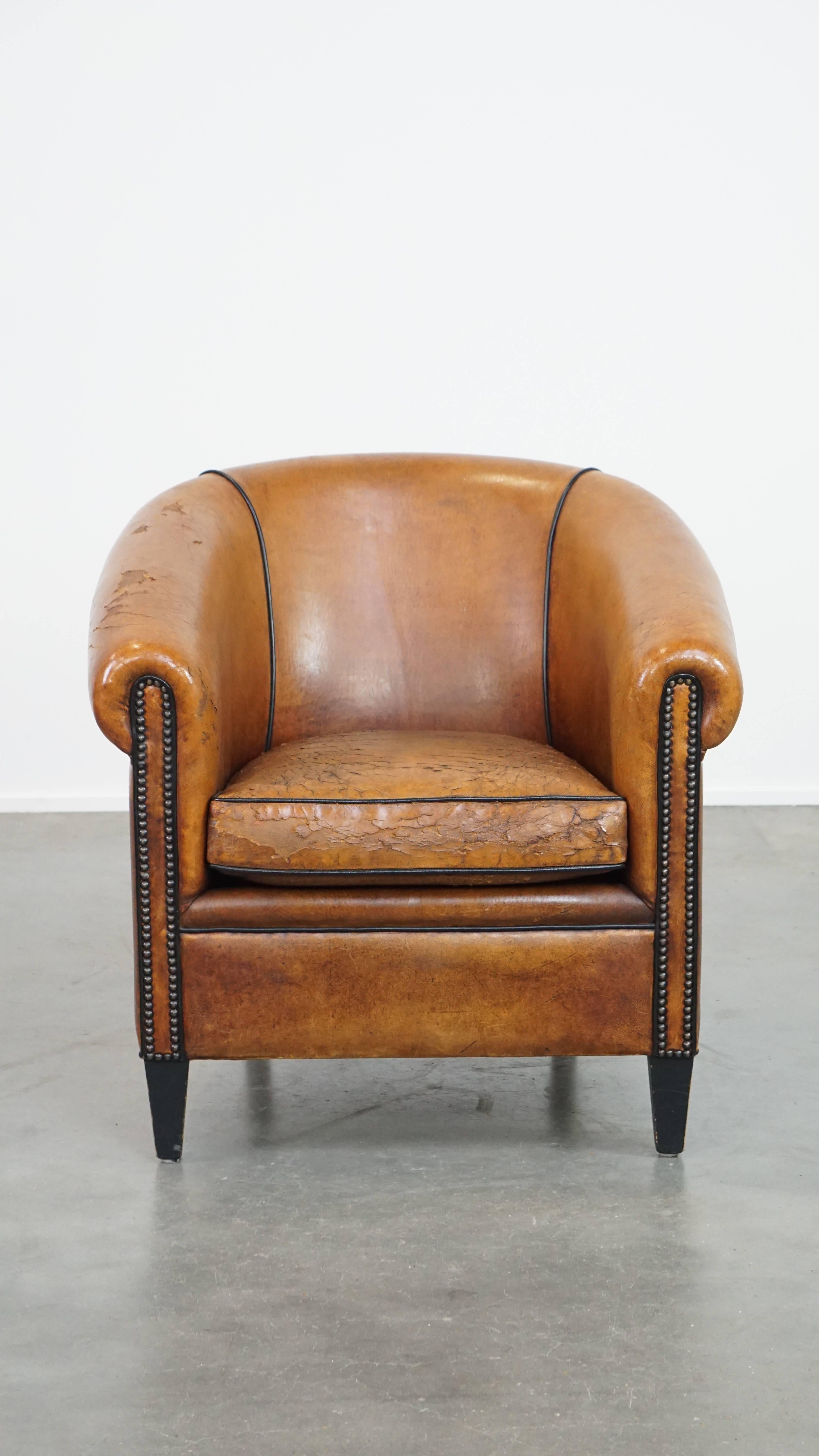 Well-worn but also stately; this fabulous sheep leather club chair is the best of 2 worlds. It is brimming with character, has a tough, worn look and its finish with decorative nails and black piping completes its look. If it is up to us, this club