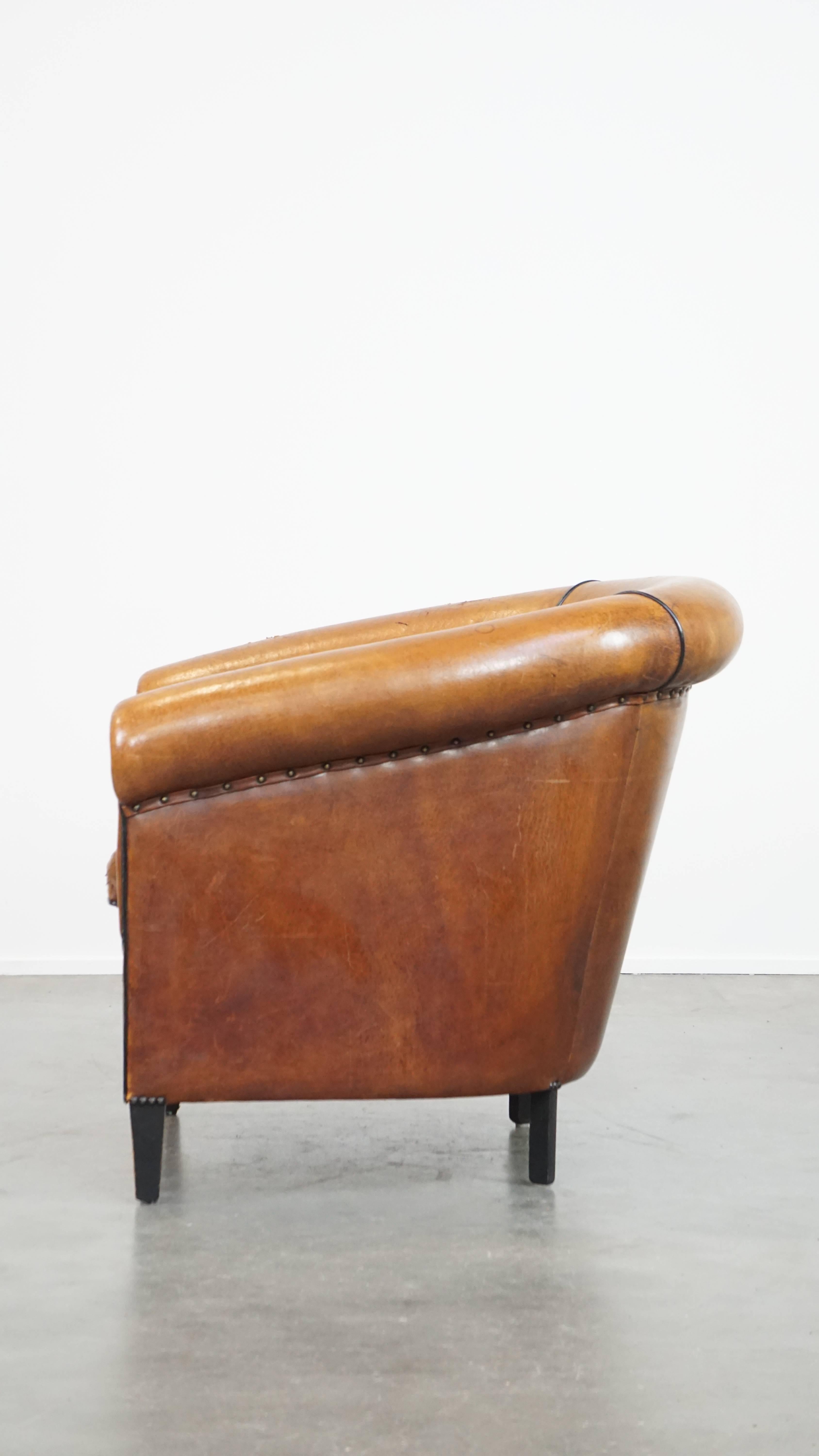 20th Century Characterful sheepskin club chair with a tough worn look and a beautiful patina For Sale