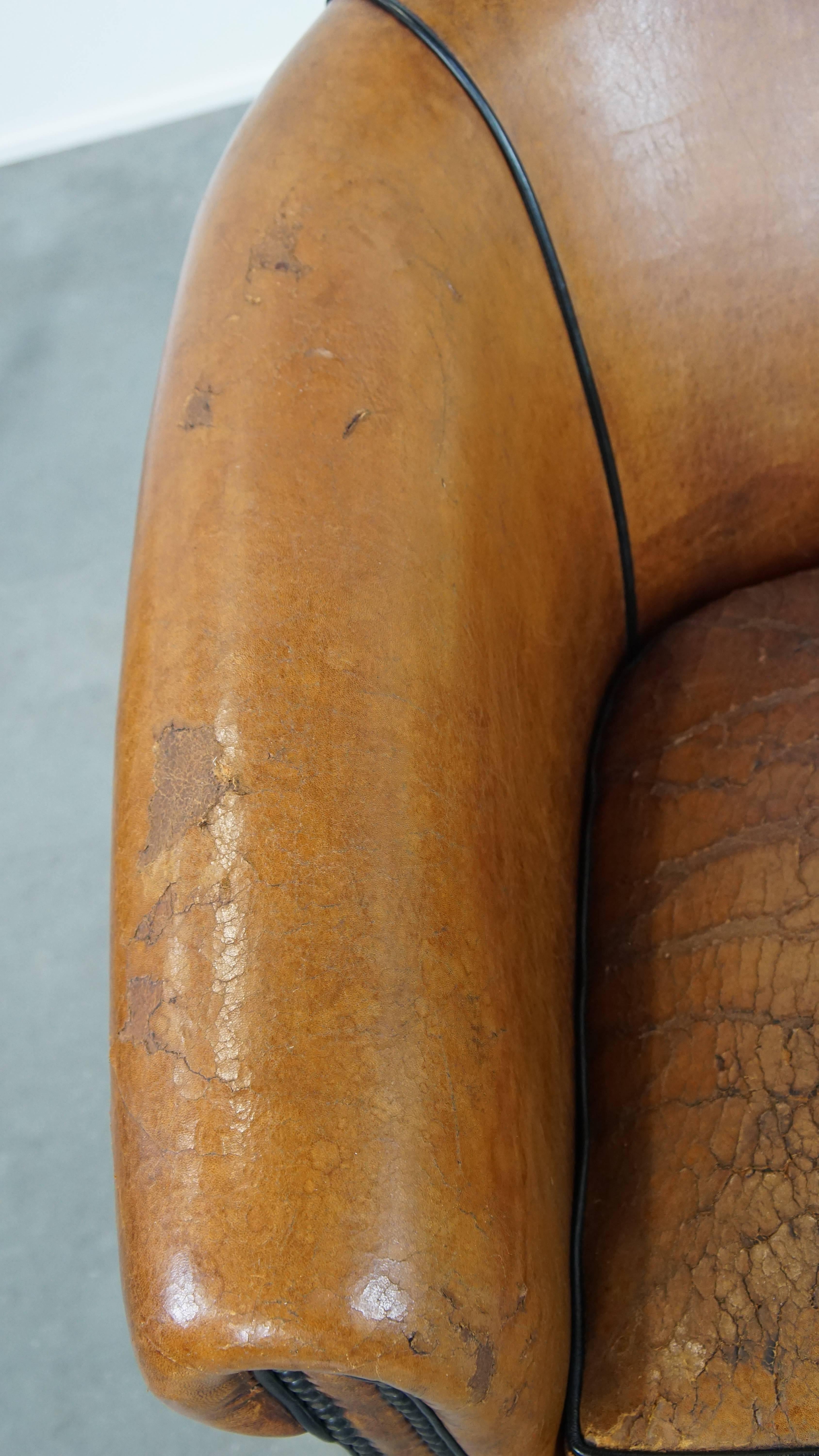 Characterful sheepskin club chair with a tough worn look and a beautiful patina For Sale 1