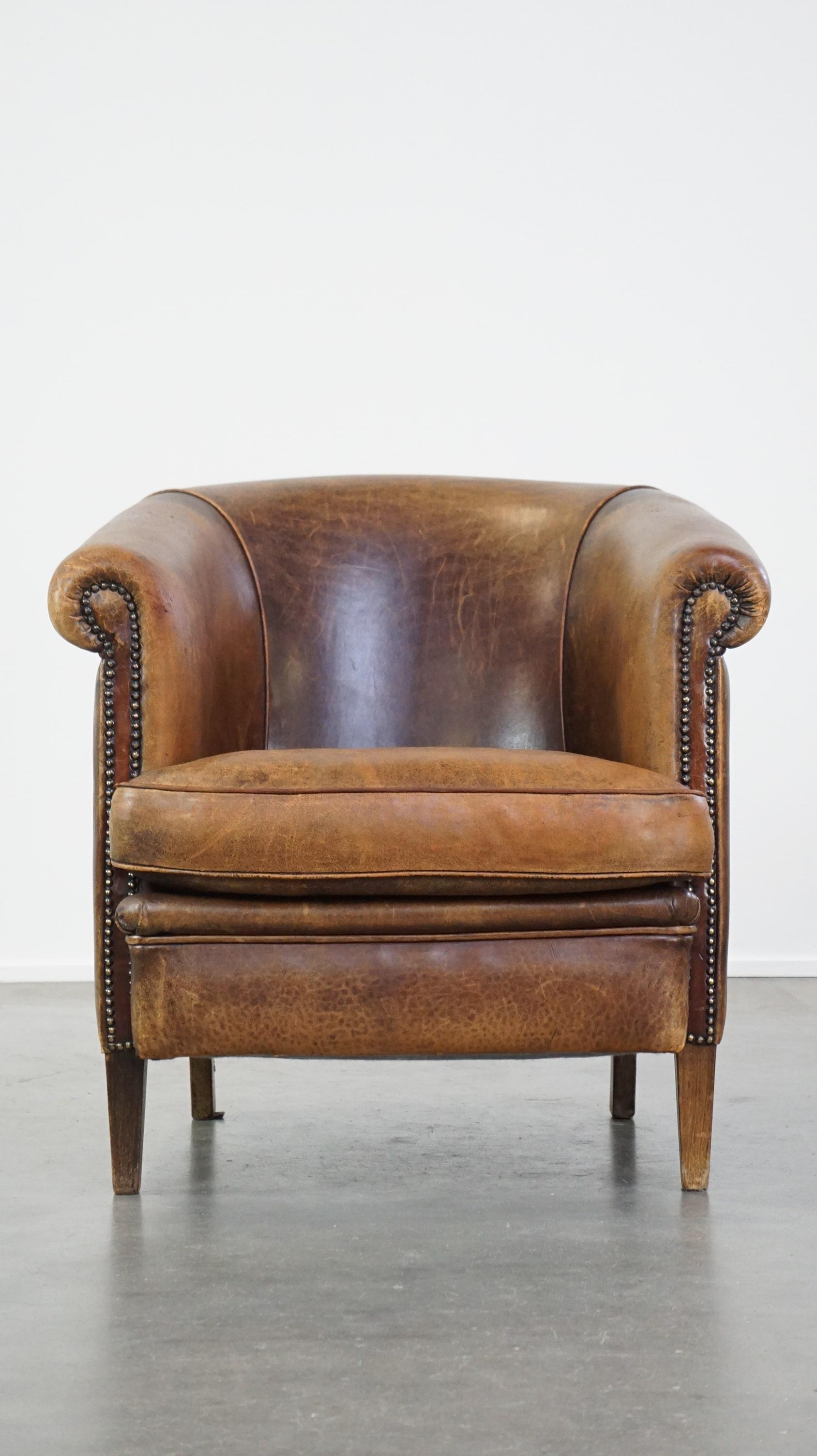 Ce superbe fauteuil club en cuir de mouton a un caractère très expressif, ce qui en fait un véritable accroche-regard. Il présente un bel aspect rustique et peut facilement s'intégrer dans presque tous les intérieurs. Il est équipé d'un coussin