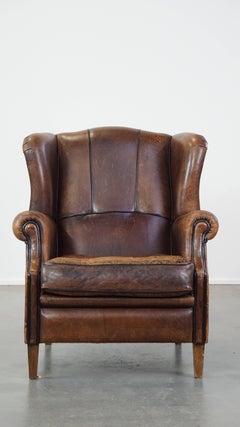 Characteristic and comfortable sheepskin wingback armchair with beautiful patina