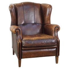 Characteristic and comfortable sheepskin wingback armchair with beautiful patina