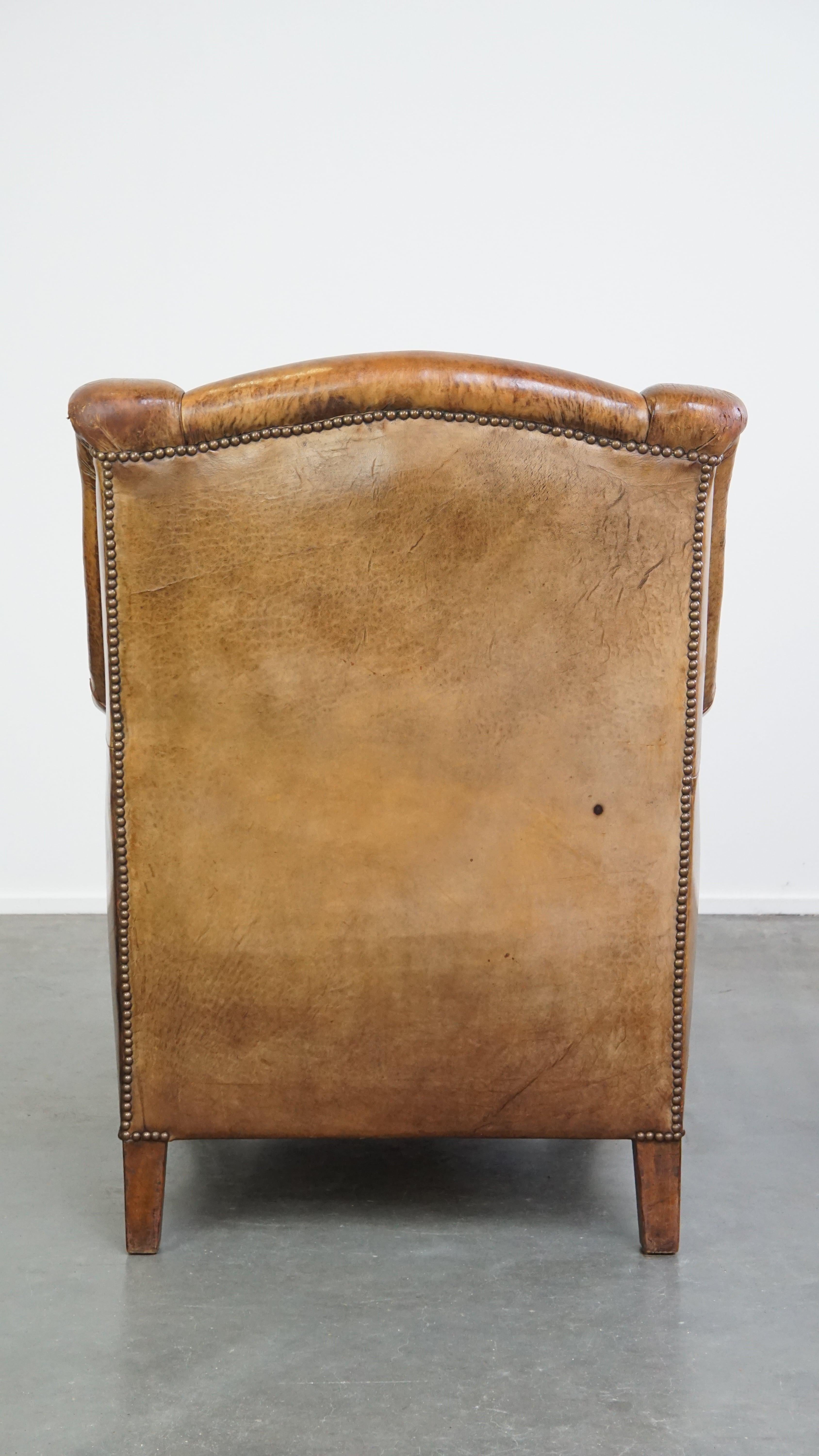 Characteristic antique sheepskin leather armchair with beautiful unique details In Fair Condition For Sale In Harderwijk, NL