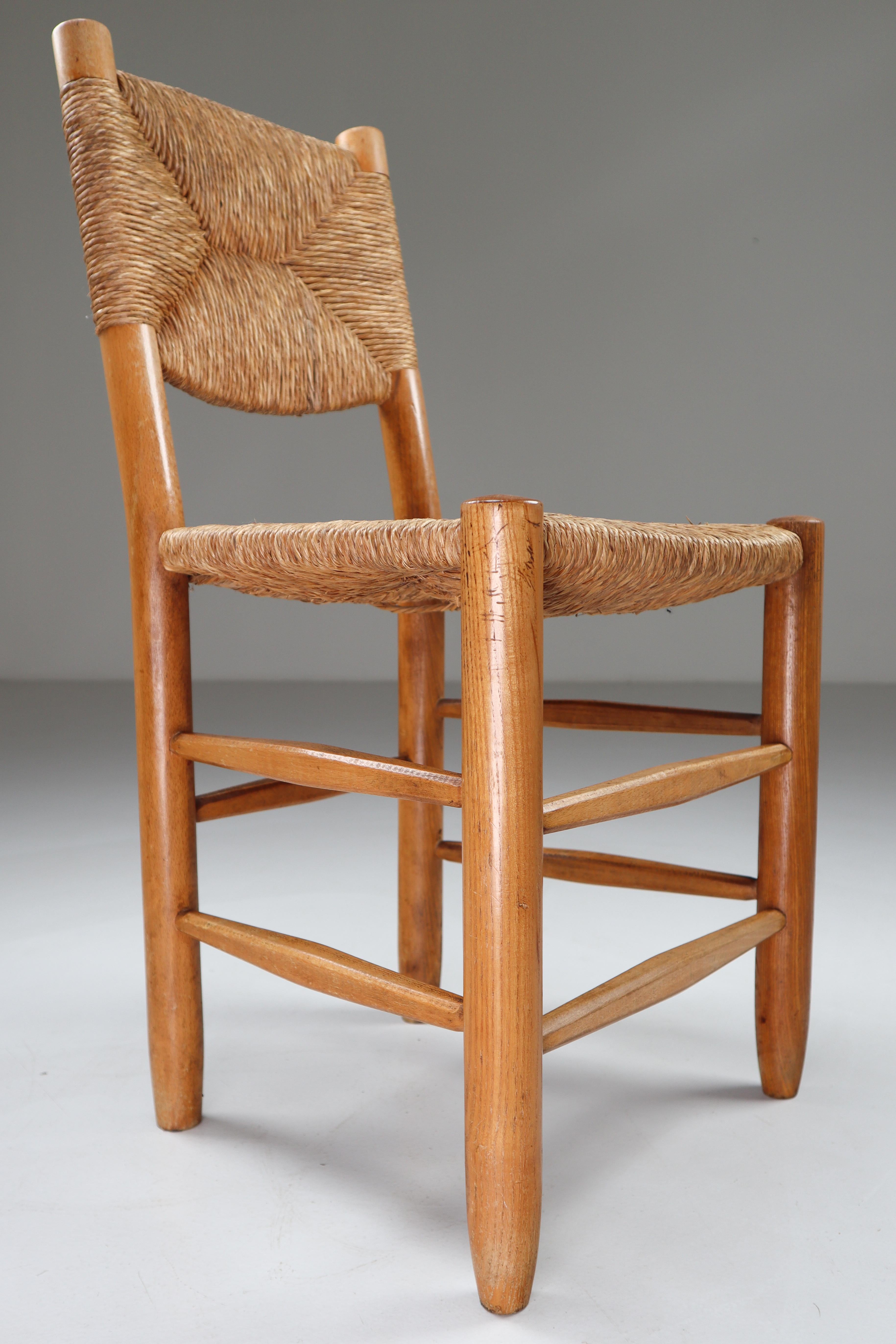 Characteristic chair of wood and straw in one of the quintessential midcentury designs of their creator, the famous French furniture maker Charlotte Perriand. The chair is in a great original condition and have a great patina and natural wear to the