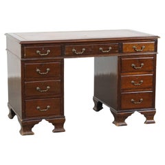 Characteristic, well-worn English desk with a leather desktop and 9 drawers