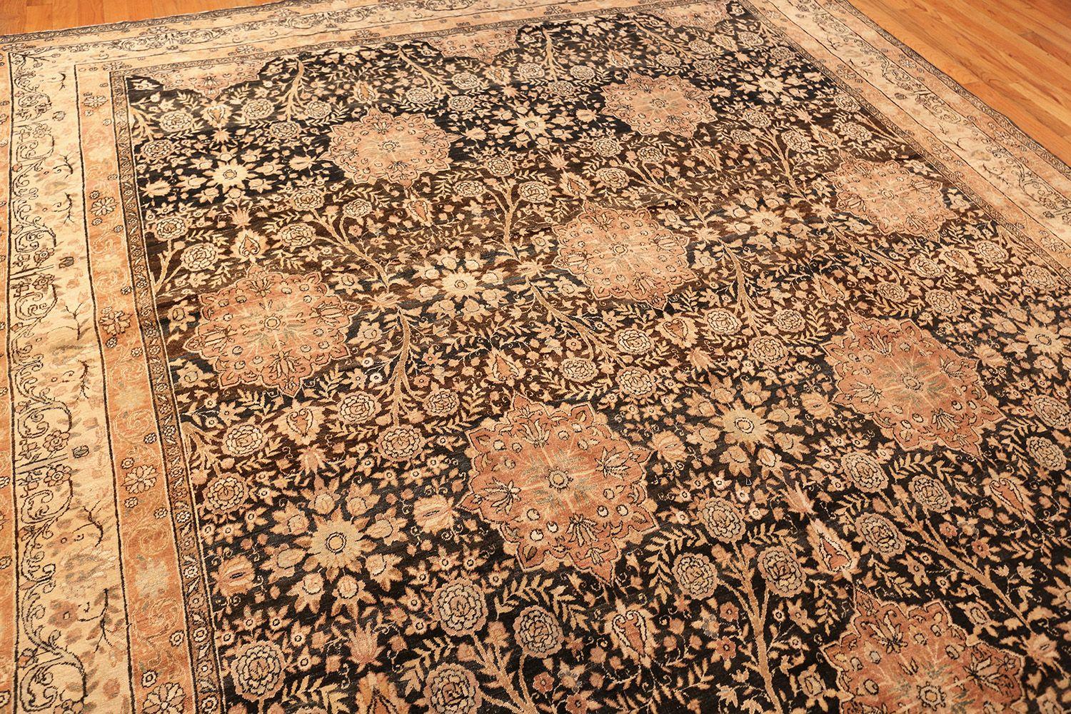 Beautiful Charcoal Colored Background Floral Antique Persian Kerman Rug, Country of Origin / Rug Type: Persian Rugs, Circa Date: 1900. Size: 9 ft 9 in x 14 ft 6 in (2.97 m x 4.42 m)

A pattern of sunset-hued stars surrounded by white roses on a