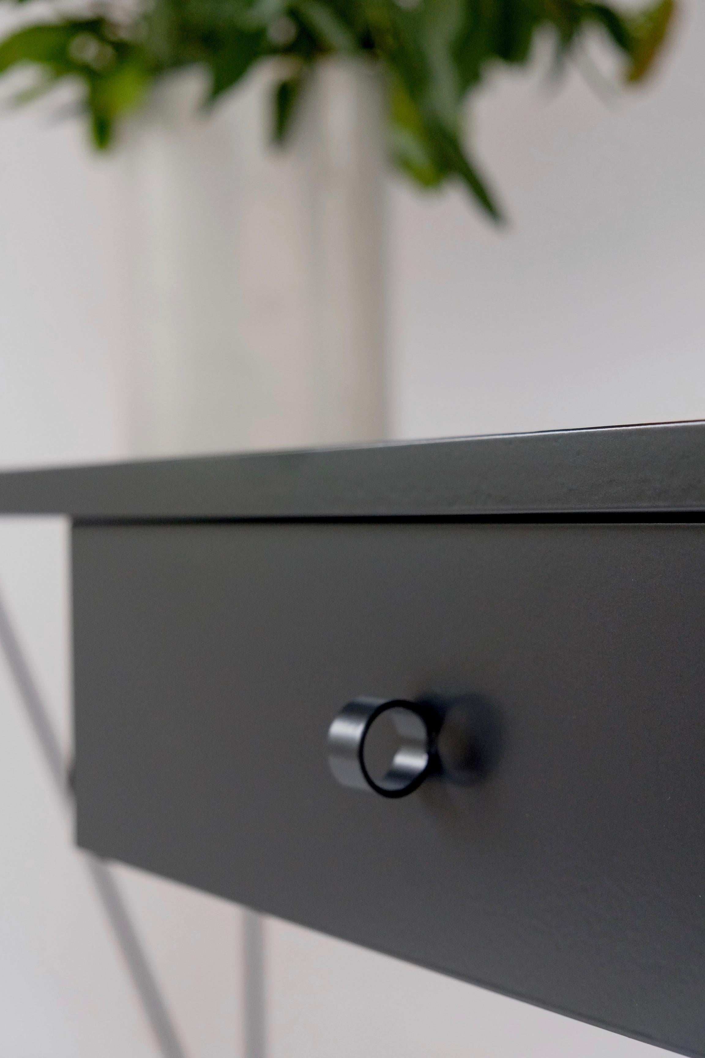 This large black study desk is made with a powder coated steel frame and a beautiful natural linoleum top made out of linseed oil. This modern minimal desk has a single steel drawers suspended underneath the table top with our loop handle. The