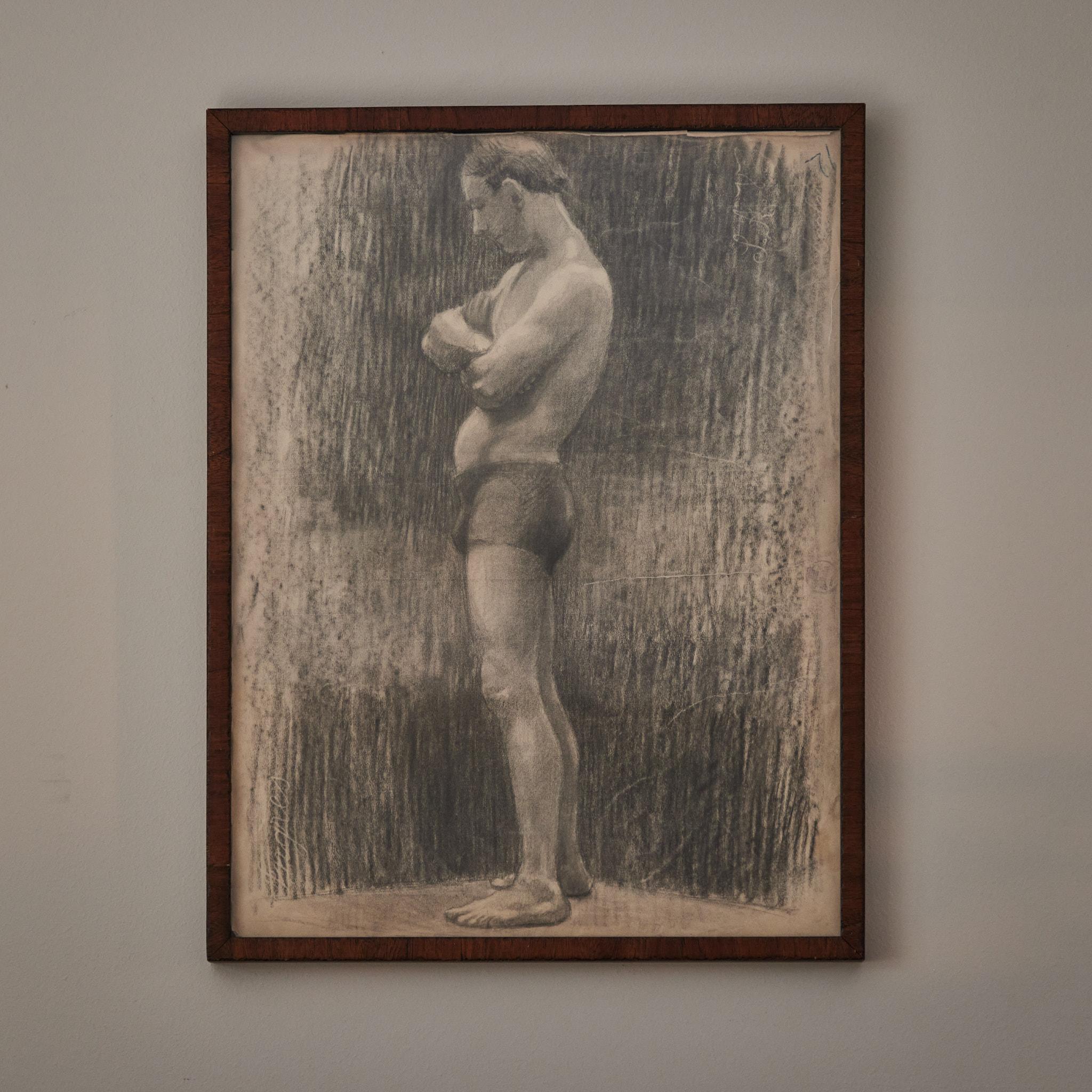Early 20th-century French Academy-style charcoal drawing of standing male model. Mounted in a custom wood frame, the image has a pensive quality, and a beautiful treatment of light and shadow.
