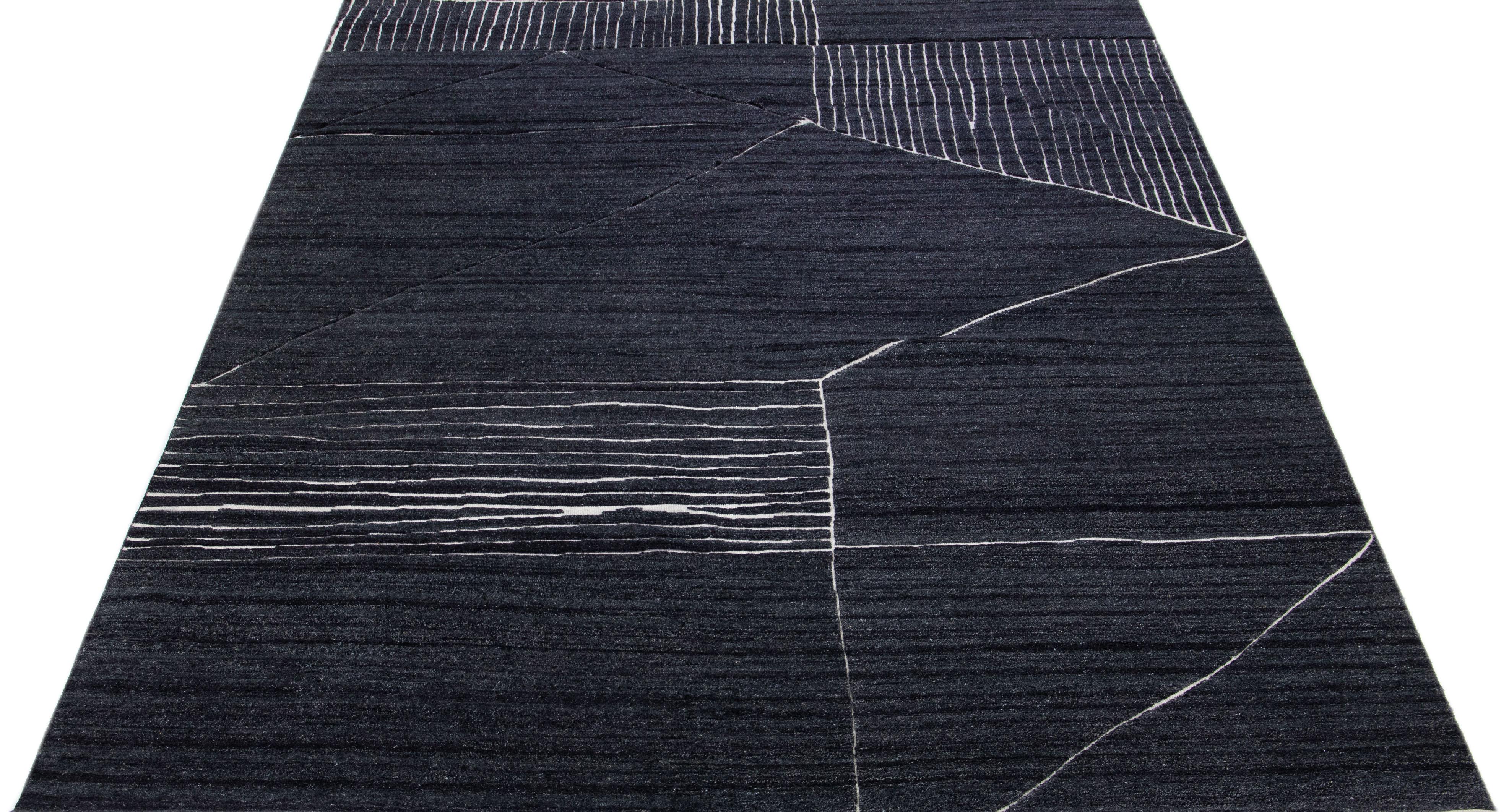 Magnifique tapis moderne en laine nouée à la main de style marocain avec un champ de couleur anthracite. Ce tapis fait partie de la collection Safi d'Apadana et présente un motif géométrique en blanc.

Ce tapis mesure : 10' x 13'11