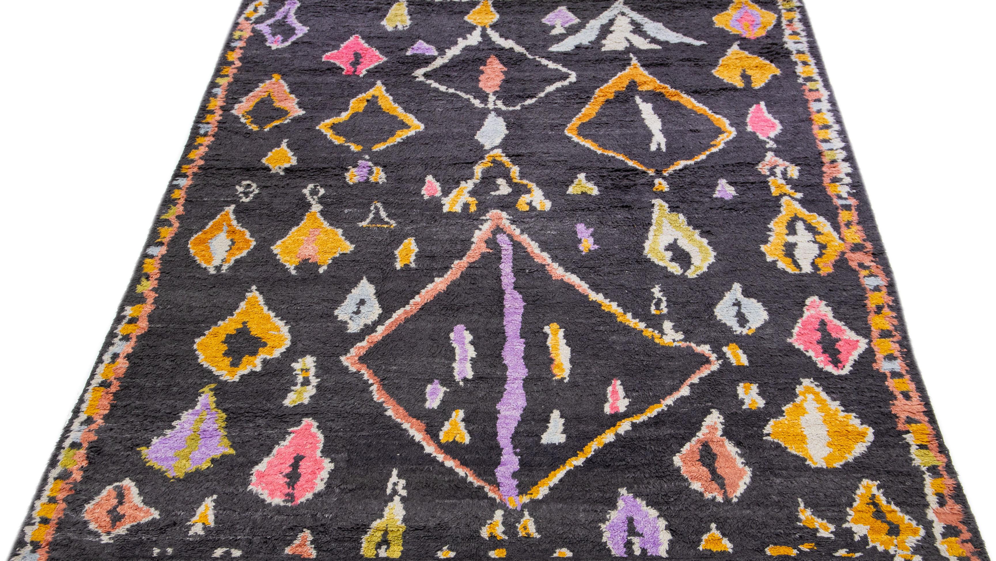 Ce tapis artisanal d'inspiration marocaine présente un captivant motif abstrait à rayures dans différentes couleurs étonnantes, qui a été méticuleusement noué à la main à l'aide de laine de haute qualité.

Ce tapis mesure 9'5