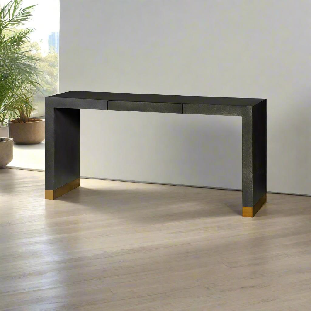 This table showcases a smooth, waterfall-style top that seamlessly flows into the ends. A centered storage drawer is integrated into the apron, offering both style and convenience. 

The console table features a hand-painted Charcoal finish, adding