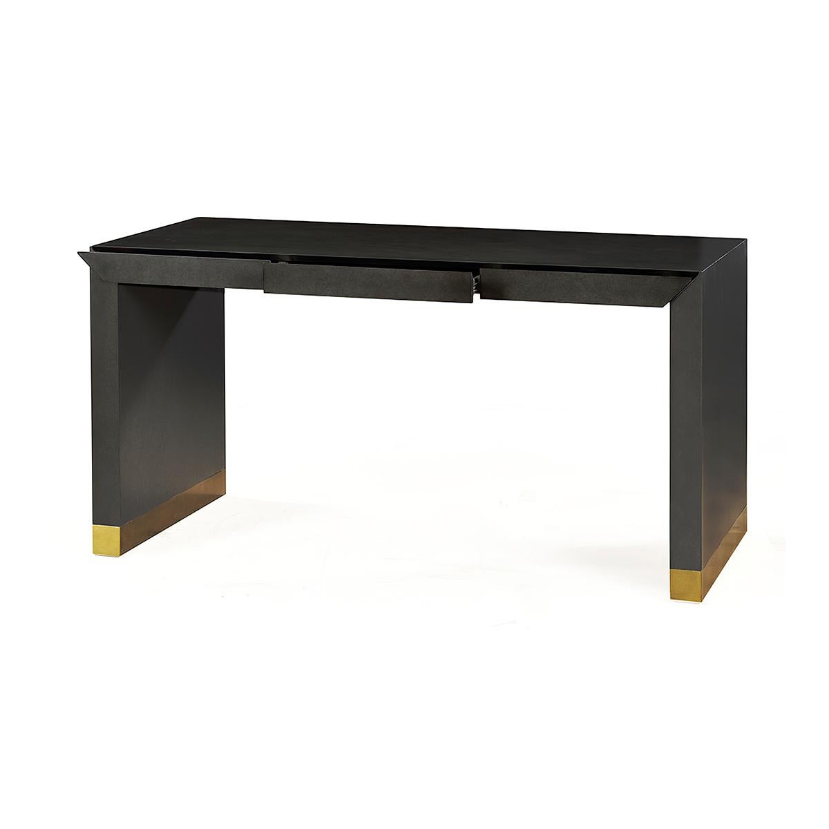 Eine perfekte Mischung aus moderner Eleganz und Funktionalität. Die glatte, wasserfallartige Tischplatte geht nahtlos in die drei in die Schürze integrierten Schubladen über, die sowohl Stil als auch Komfort bieten. 

Der Schreibtisch ist in