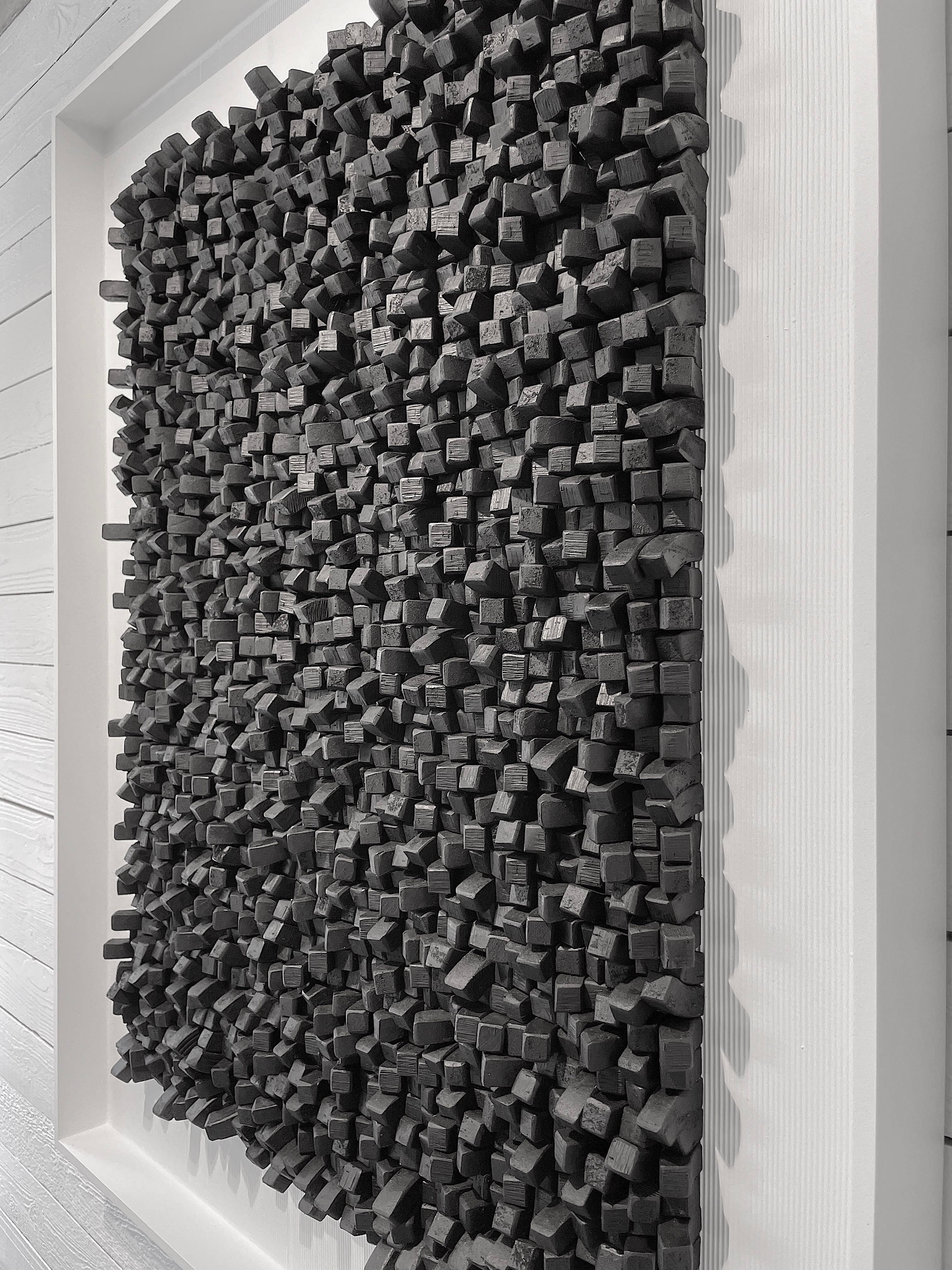 Contemporary artist Guy Leclef folded charcoal colored paper into small cubes give a three dimensional appearance.
Creates a very unique and dramatic wall sculpture.
Vertical ribbed textured matting and white wood frame.

