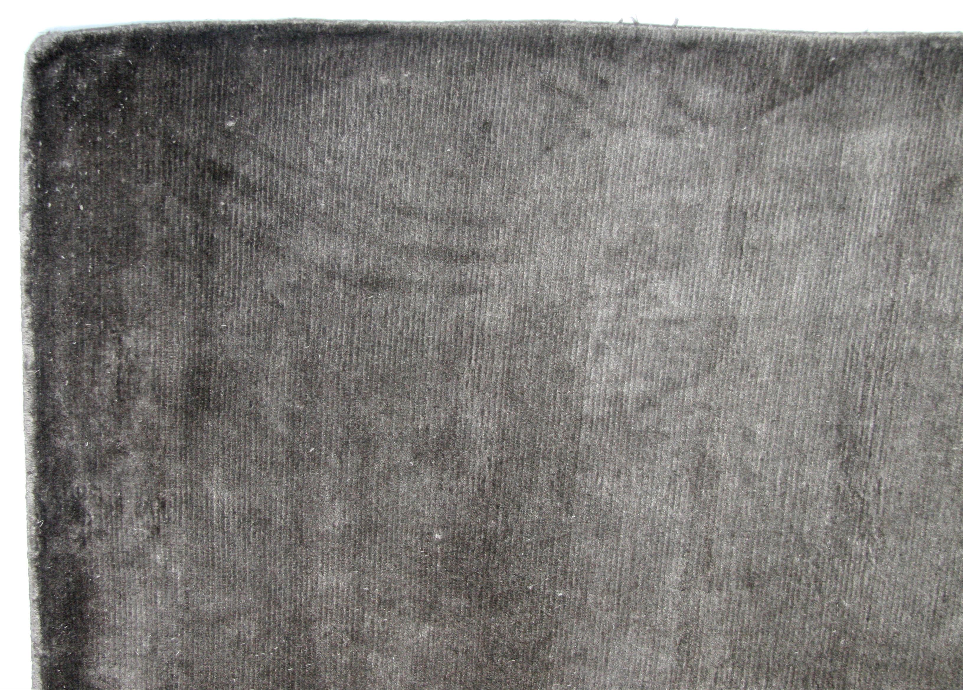 Plush, solid-color wool area rug for the contemporary home or office. Durable all-wool, hand knotted construction. Hand-knotting technique creates a 'light' and 'dark' side (shown here) when viewed from different angles. Made in India using natural