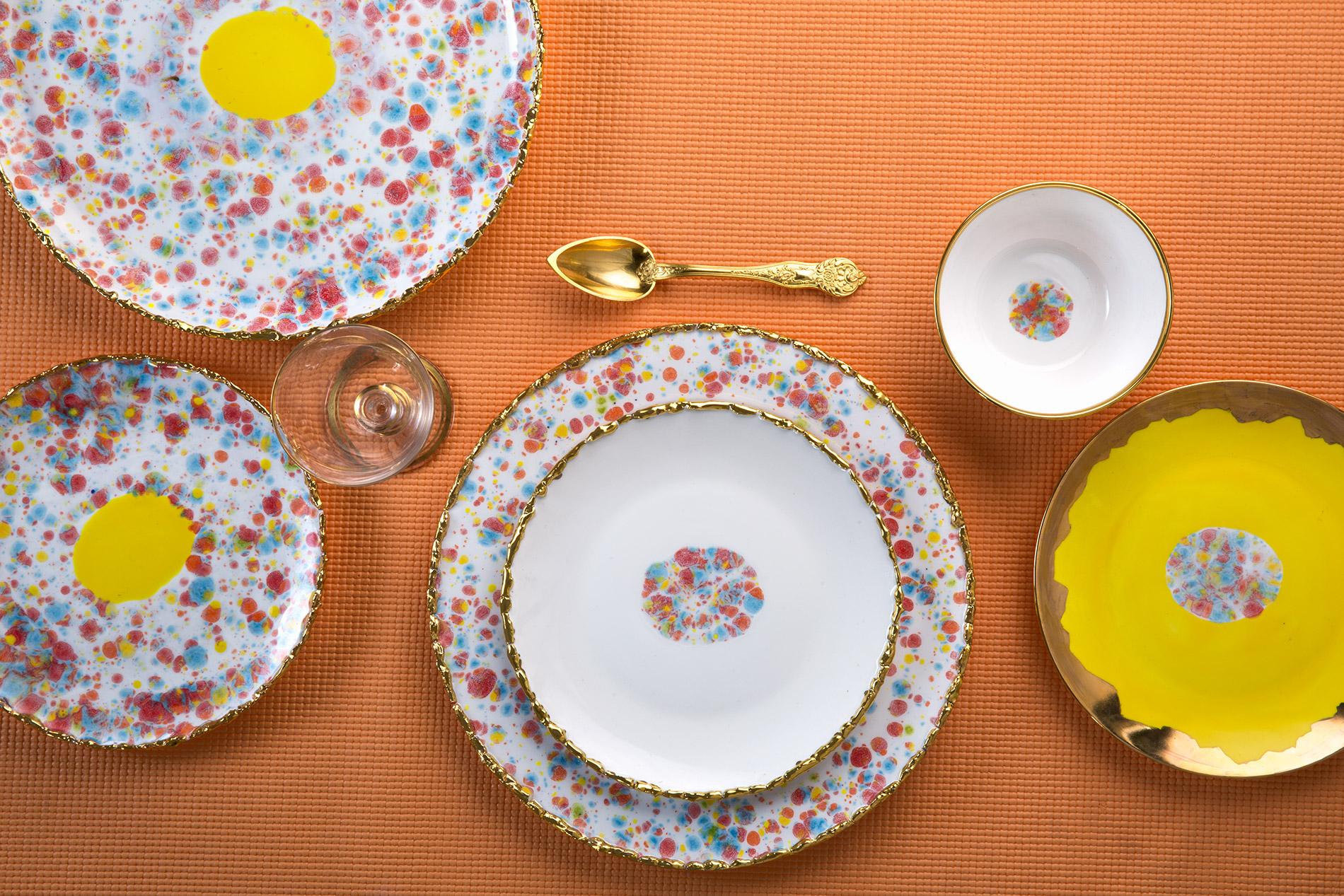 Handcrafted in Italy from the finest porcelain, this Craquelé Edge rim charger from the Confetti collection has an original golden crackled rim emphasizing the lively multi-color enamel and the yellow dot at its center.

Craquelé Edge rim charger,