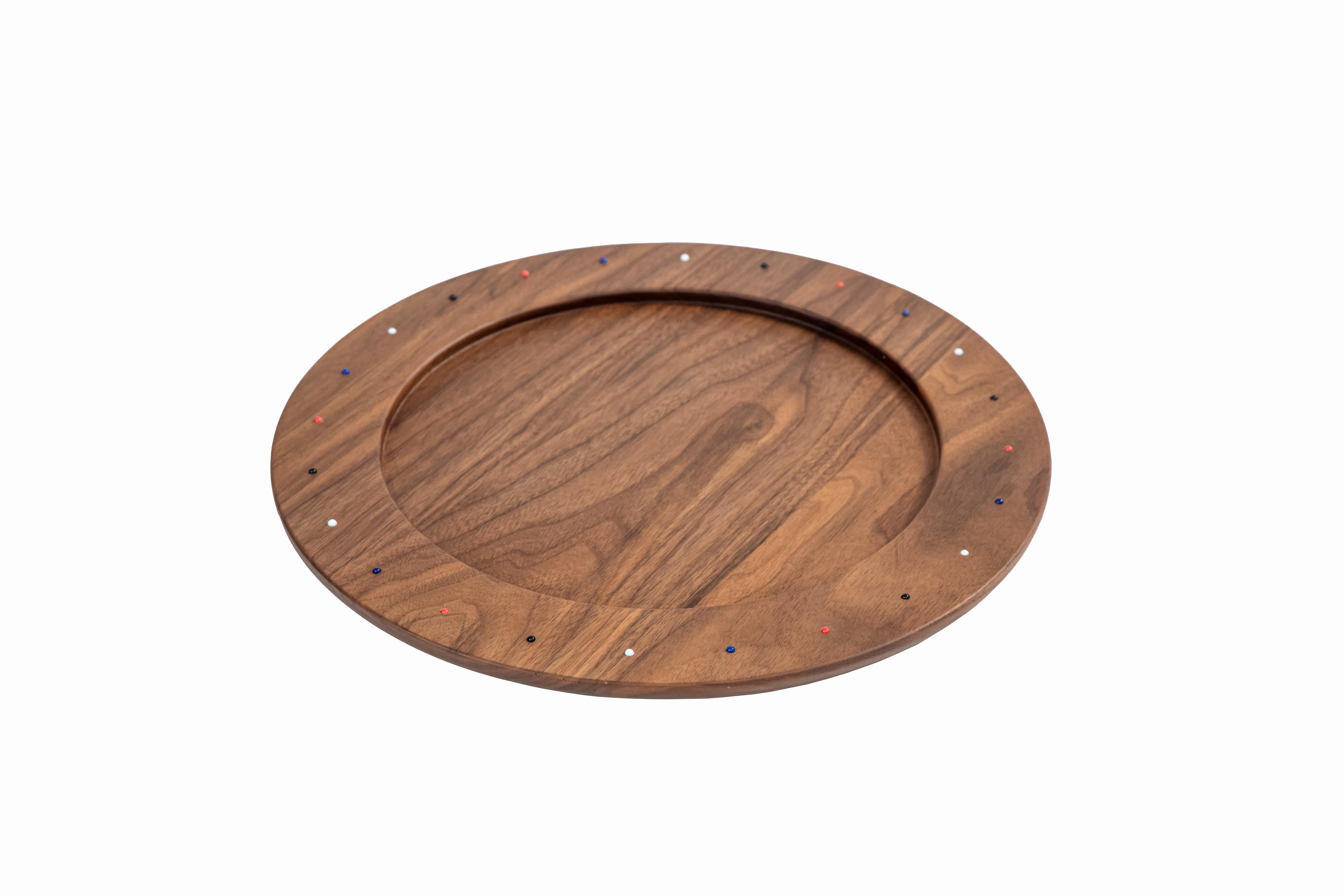 This SoShiro Pok collection piece is a perfectly round wooden charger plate or table centrepiece carved from one solid piece of walnut wood and embedded with hand-placed glass pearl bead ornamentation. 

The Pok collection celebrates the artistry of