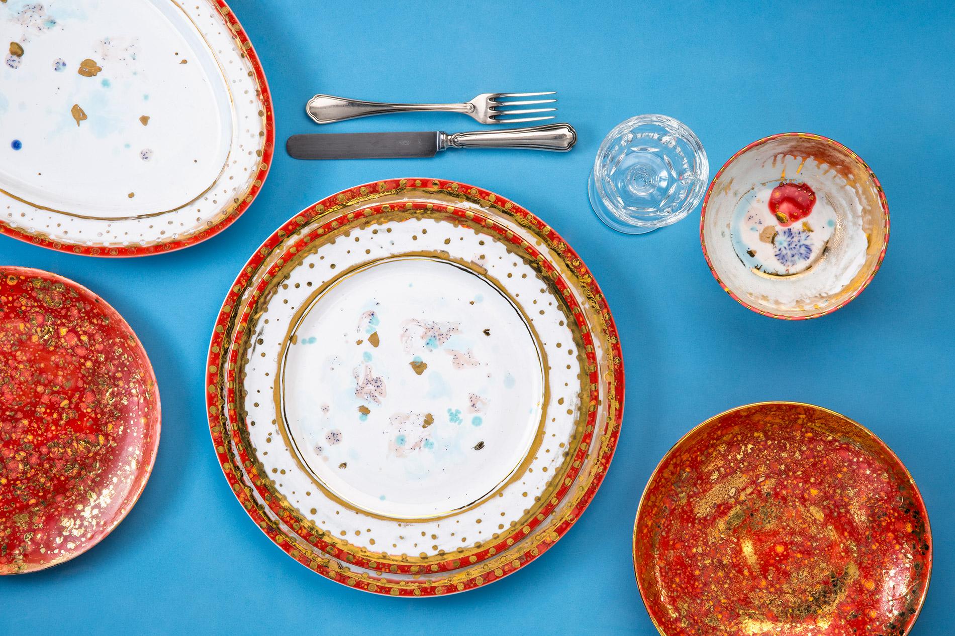 Hand painted in Italy from the finest porcelain, this Scipione charger plate has the rim sprinkled with a light decor of golden dots and thin circles all around, all around the edge, a narrow, African red rim, punctuated with golden dots; at the