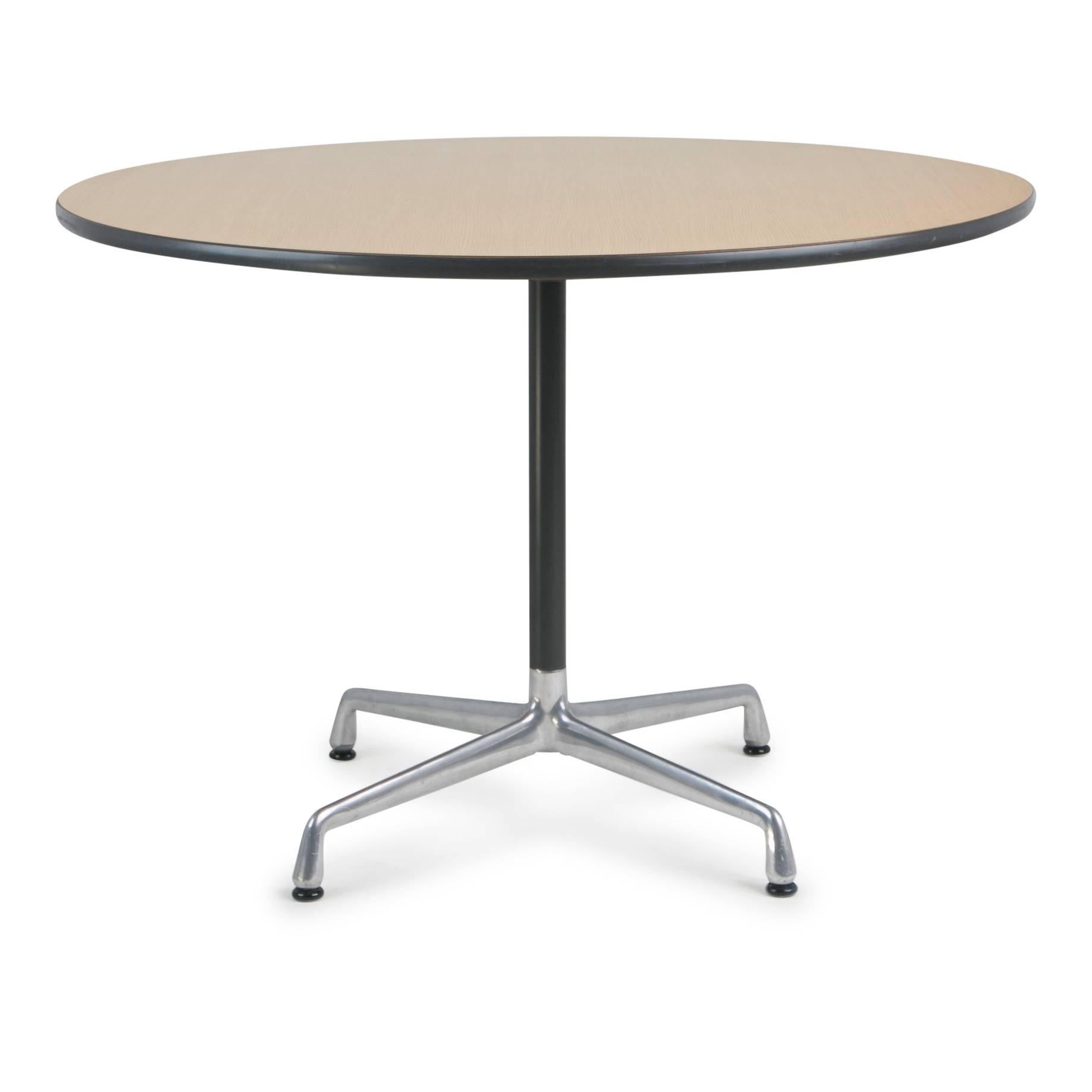 Herman Miller Aluminum Group dining or cafe table designed by Charles and Ray Eames, circa 1970. This minimalistic table is comprised of an aluminum pedestal four-star base with a wood laminate top. The size is perfect for a kitchen or breakfast