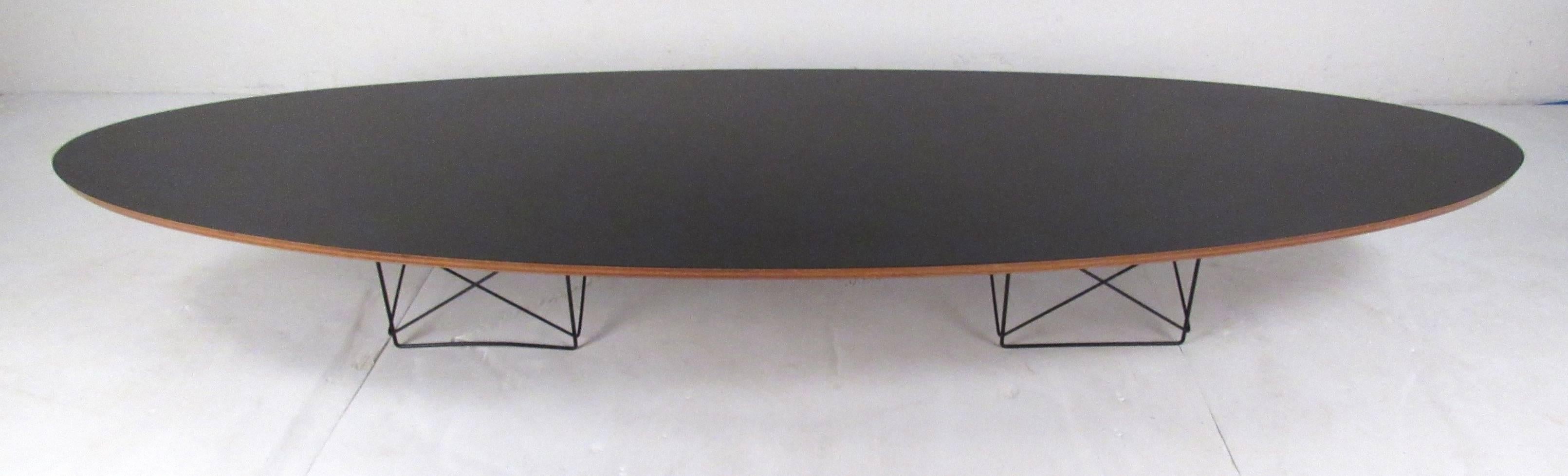 Classic design by Charles & Ray Eames, 1951. Two wire bases support a long, elegant, oval top covered in black laminate. Excellent vintage example with lovely patina expected from its age and use.