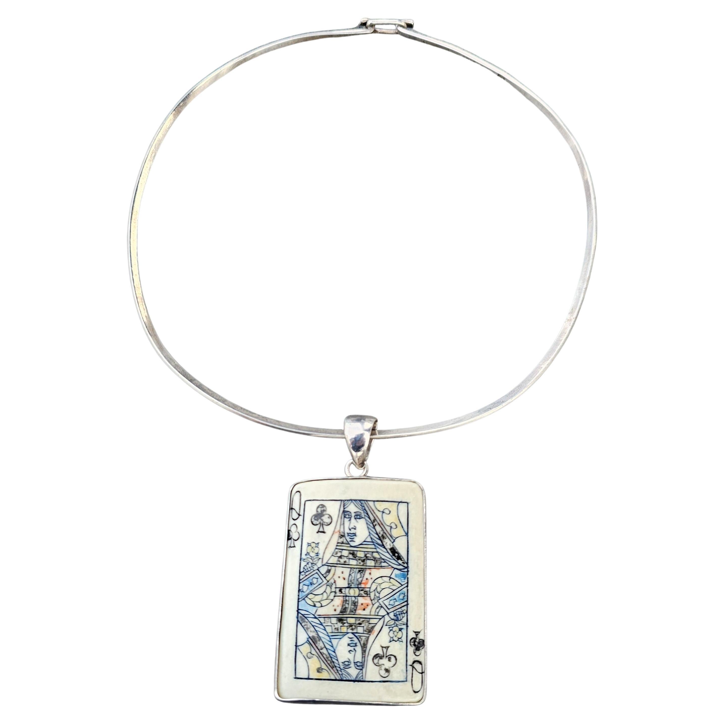 Enhance your jewelry collection with this unique Charles Albert pendant necklace. Crafted from sterling silver, this piece features a rectangular pendant adorned with a Queen of Clubs playing card design. The intricate detailing adds a touch of