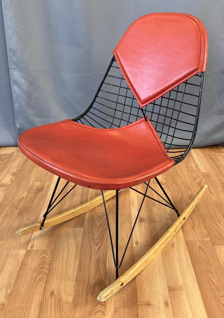 Offered here is a Charles and Ray Eames designed 1st Generation RKR Rocker for Herman Miller
Two Birch wooden rockers, steel rod base and main body of the chair, then a burnt orange bikini seat cover.