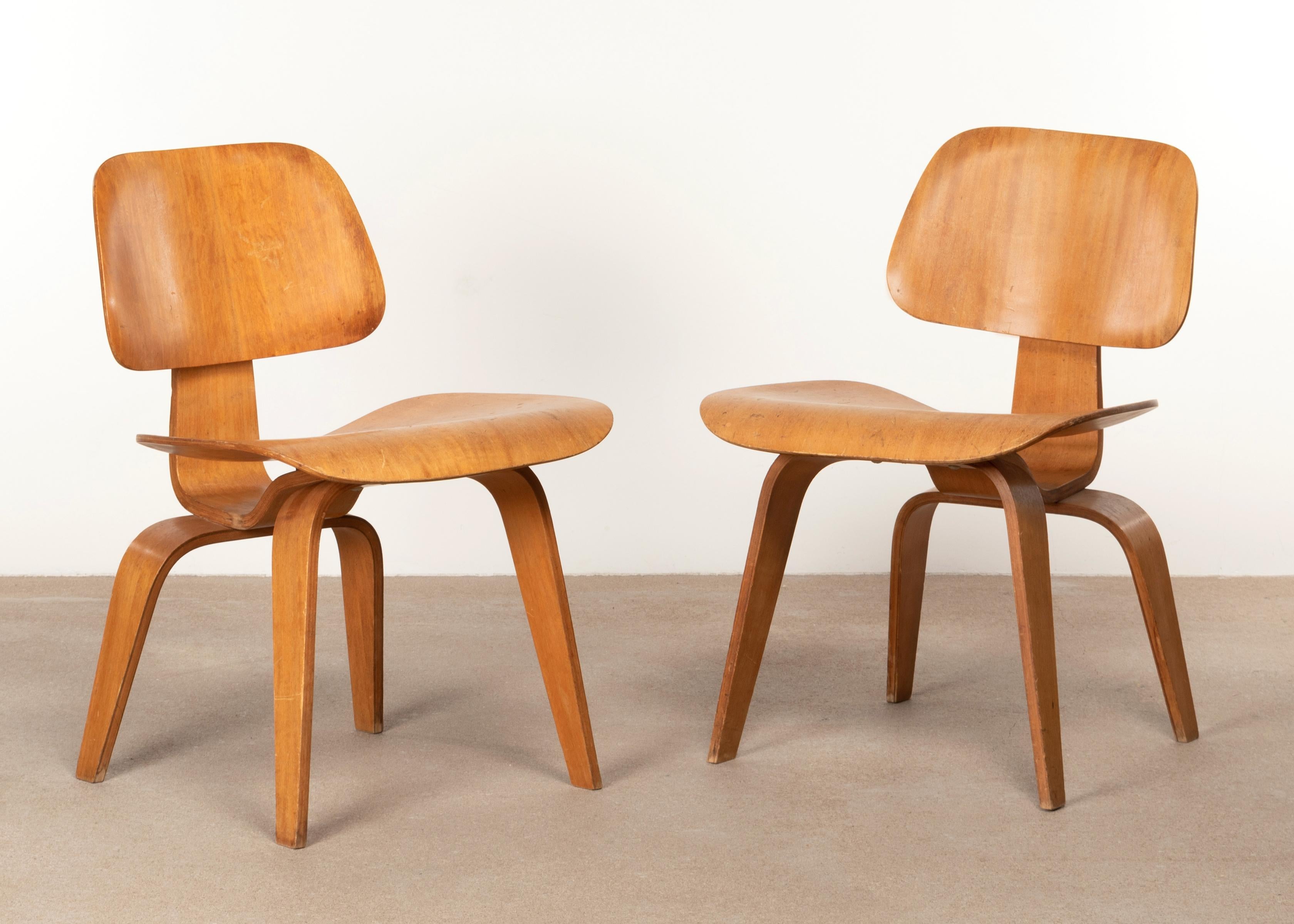 Iconic DCW dining chairs in plywood. The mahogany veneer is in good condition with patina and normal wear. Early Evans Products / Herman Miller from 1945 (5-2-5 screw configuration). Signed with manufacturer's label underside: ‘Herman Miller Evans