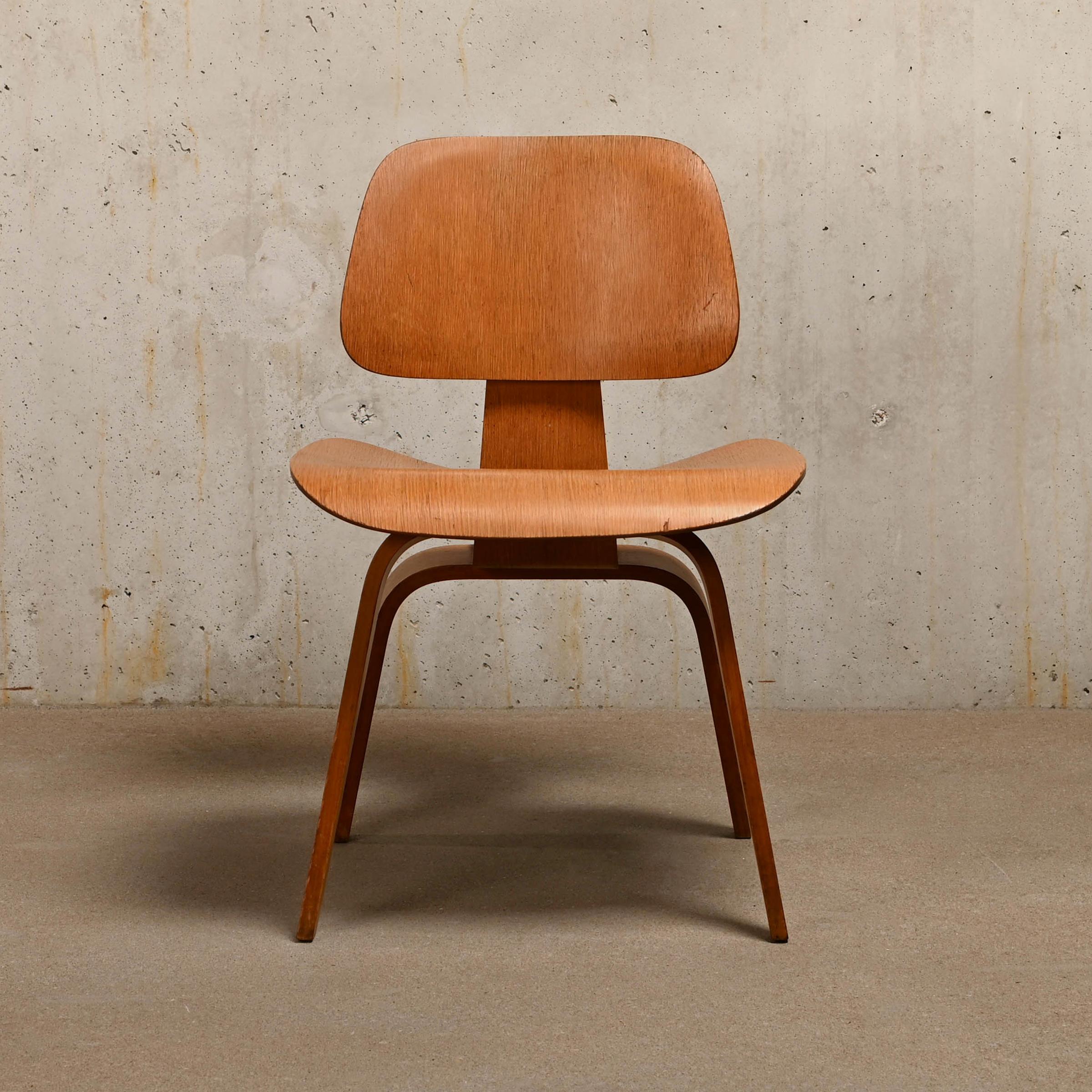 Iconic DCW dining side chair in Oak plywood. The oak veneer is in good condition with nice patina and minor user marks. Early Herman Miller production from September 1953 (4-2-5 screw configuration), just after Herman Miller took over production