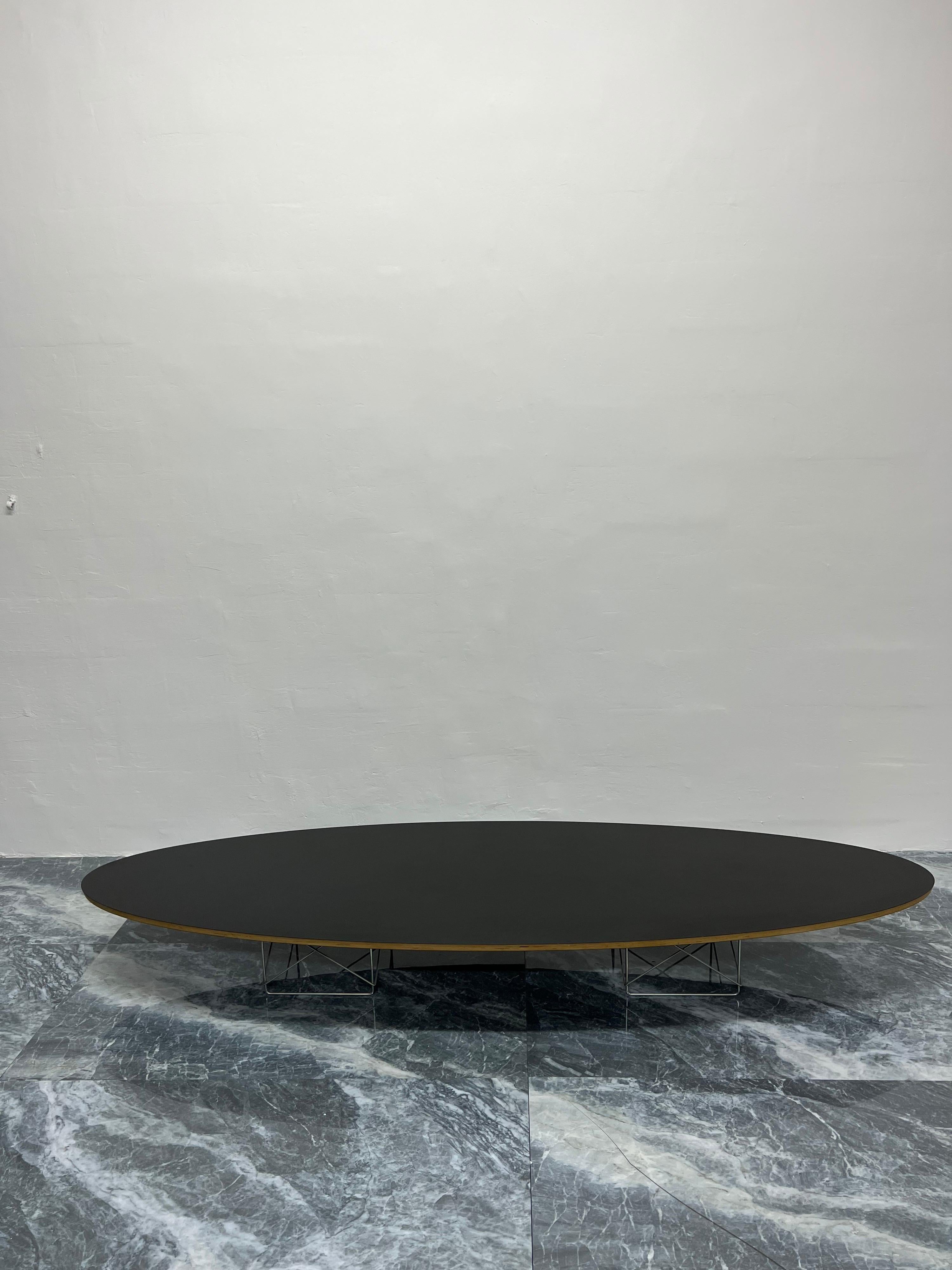 Black laminate top on steel wire frame base Eliptical coffee table designed by Charles and Ray Eames for Herman Miller. This version is from the late 1990s and maintains the Herman Miller Eames placard.

Nicknamed the “surfboard table,” the