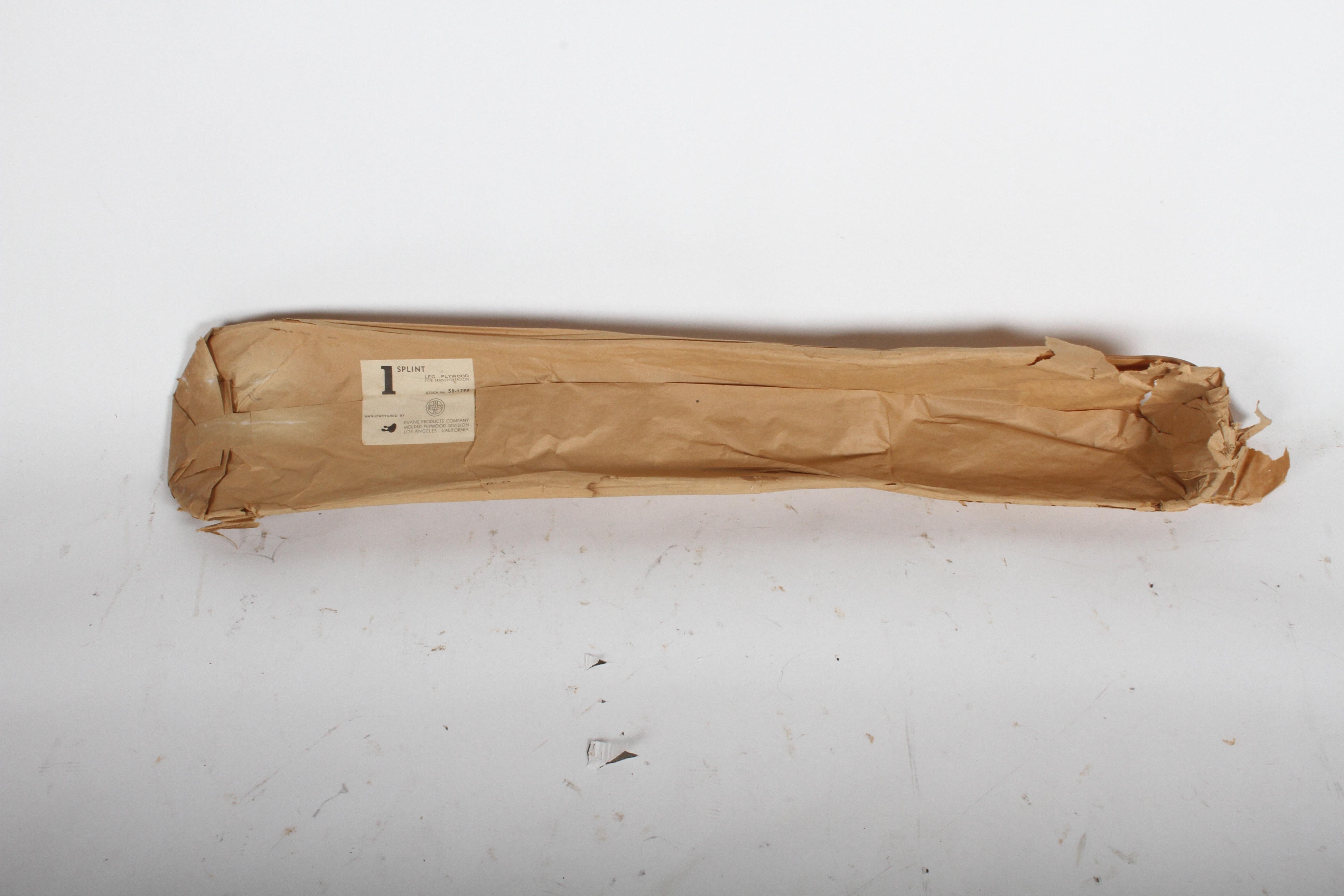 Charles and Ray Eames for Evans products plywood splint in original wrap with label.
Original Evans stamp to wood, these where used during WWII for leg splints, circa 1940s.
Sold without stand. 

Splint on metal base displayed as a sculpture is