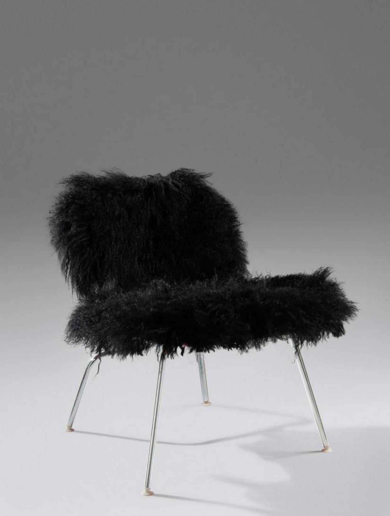 Chaise longue LCM emblématique de Charles et Ray Eames pour Herman Miller. Édition unique car le bois a été teint à l'aniline rouge et recouvert de laine d'agneau de Mongolie noire. Un design classique sans équivoque, conçu par l'équipe de designers