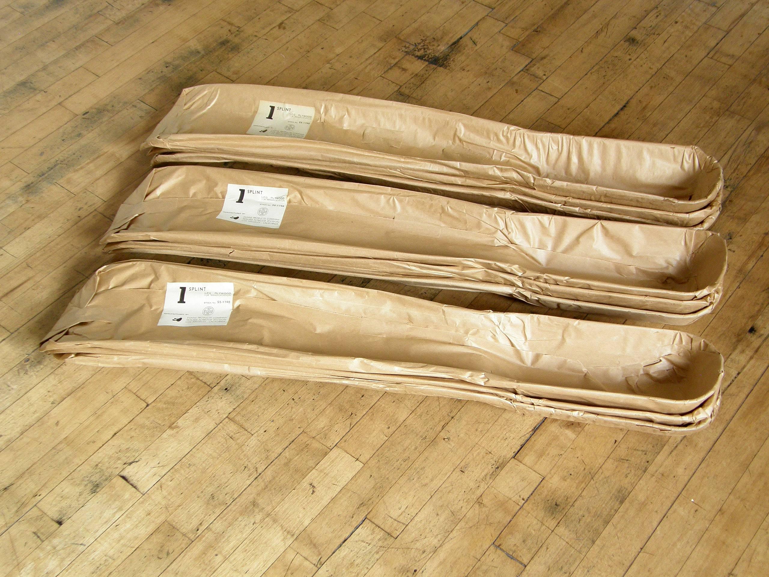 These leg splints were designed by Charles and Ray Eames and produced for the United States Navy by the Evans Products Company, molded plywood division. They're still in their original 1940s wrappers with the Ray Eames designed labels. 

Each
