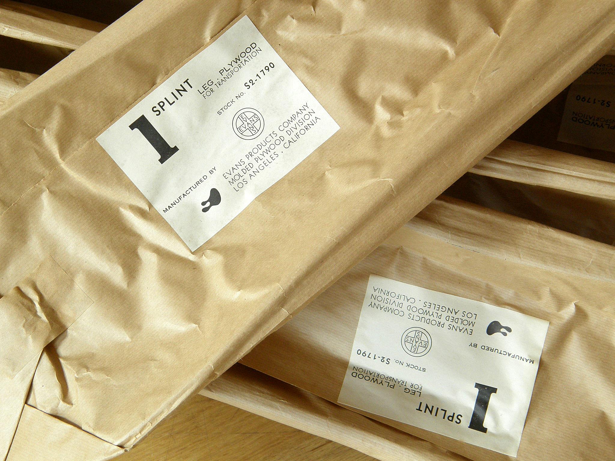 These leg splints were designed by Charles and Ray Eames and produced for the United States Navy by the Evans Products Company, molded plywood division. They're still in their original 1940s wrappers with the Ray Eames designed labels. 

Each splint