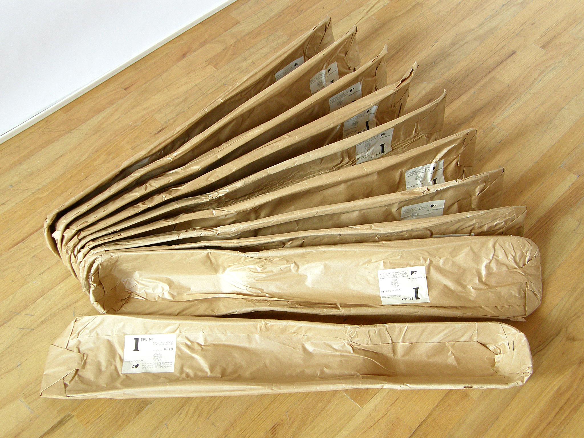 These leg splints were designed by Charles and Ray Eames and produced for the United States Navy by the Evans Products Company, molded plywood division. They're still in their original 1940s wrappers with the Ray Eames designed labels. 

Each splint
