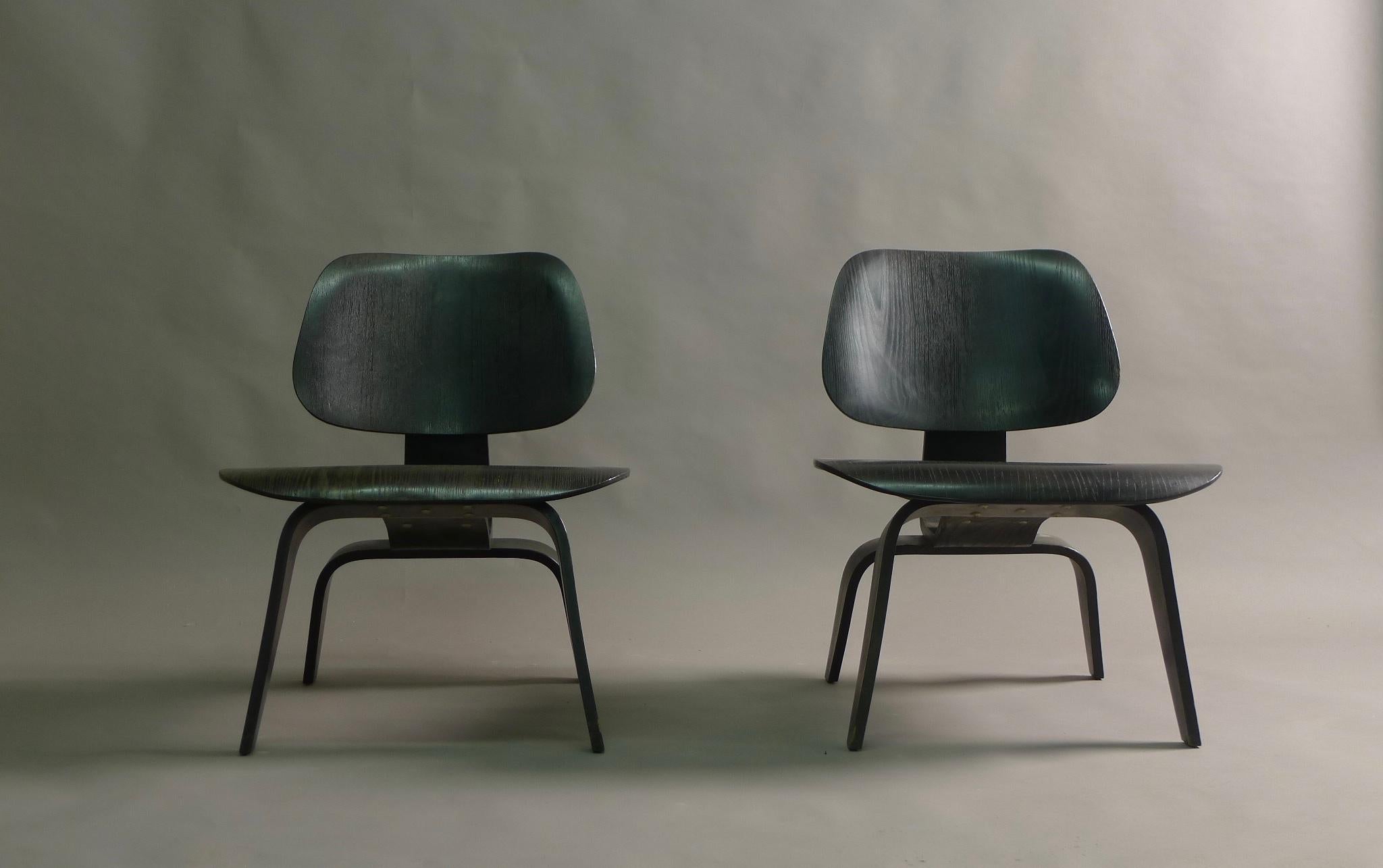 A pair of Charles and Ray Eames LCW's (Lounge Chair Wood) in original black analine dye finish. Designed circa 1946 this pair have the early 5-2-5 screw configuration as employed by the first manufacturer, Evans Plywood. 
All original shockmounts