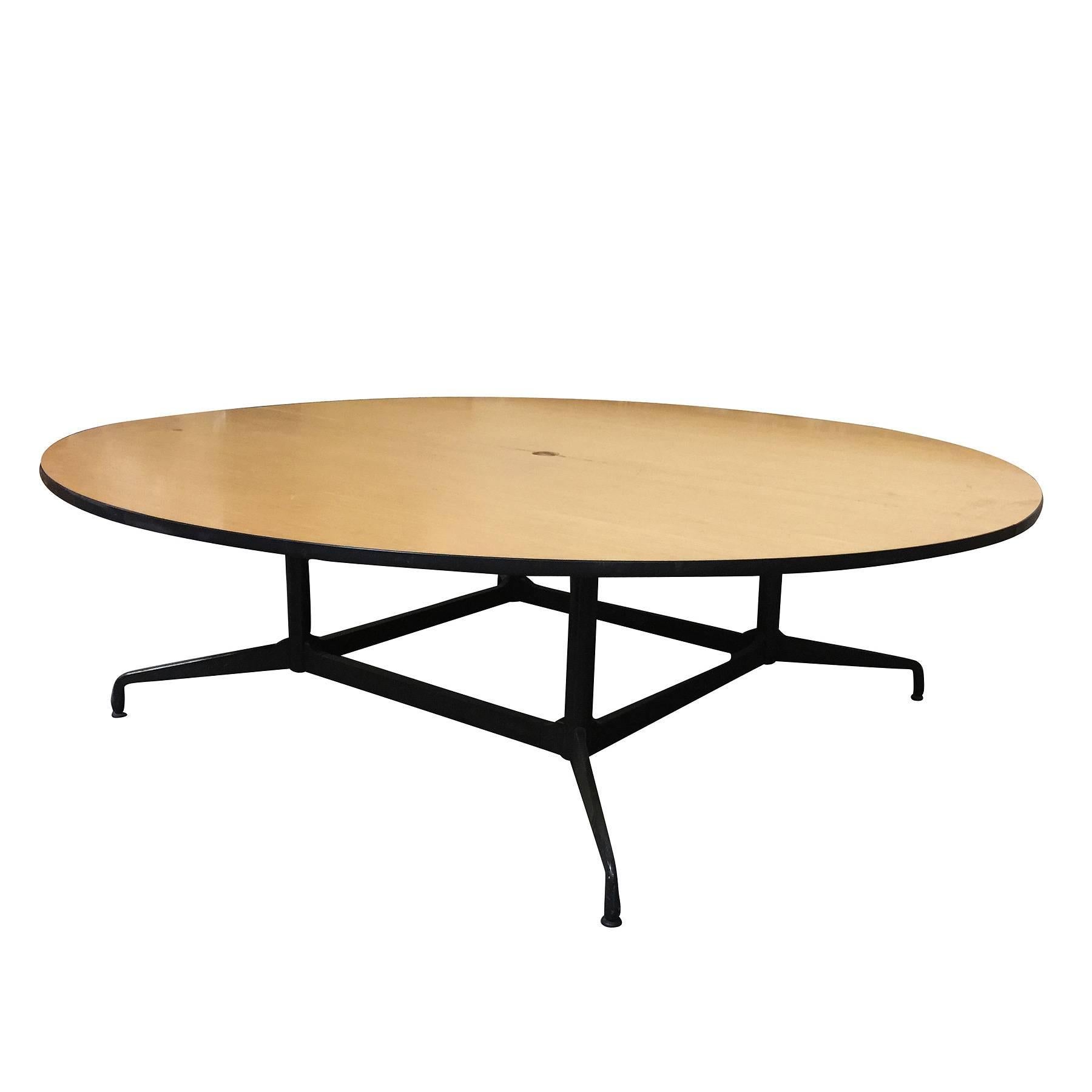 
Large 8' foot Charles and Ray Eames designed round conference table by Herman Miller. 

The table features a large two-piece round laminate oak veneer wood top with a steel and aluminum base. This is a conference table that will easily impress,