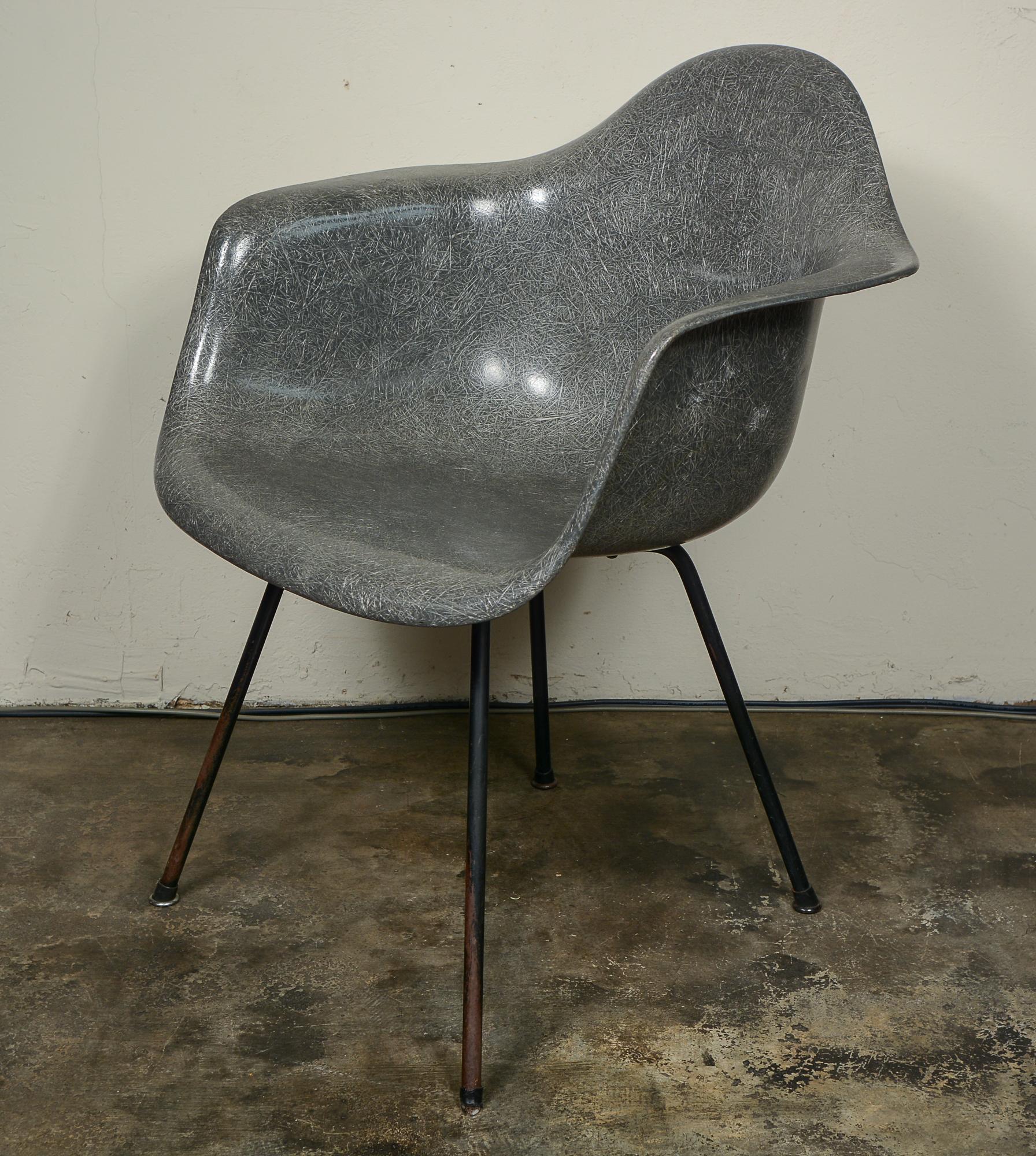 Second generation Zenith fiberglass armchair by Charles and Ray Eames. This chair is elephant hide grey. The chair is missing one glide. The screws are likely not original. There are a couple of scratches, one deeper one on the seat. There are minor