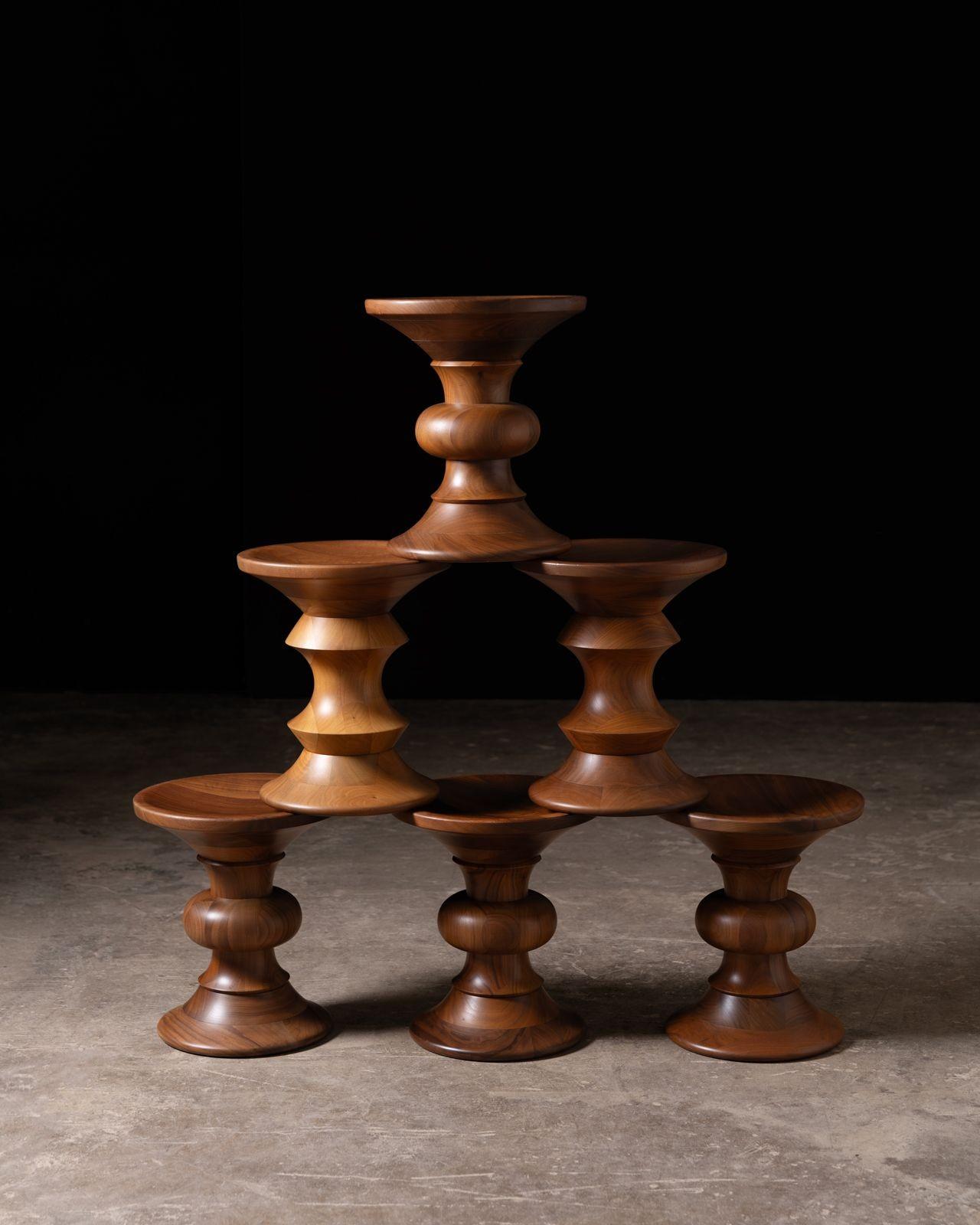 La serie di sgabelli Eames Walnut è stata progettata da Ray Eames nel 1960 per l'atrio dell'edificio Time-Life di New York. Realizzati in legno massiccio di noce o ebano tornito e caratterizzati da piani e fondi concavi, questi sorprendenti pezzi