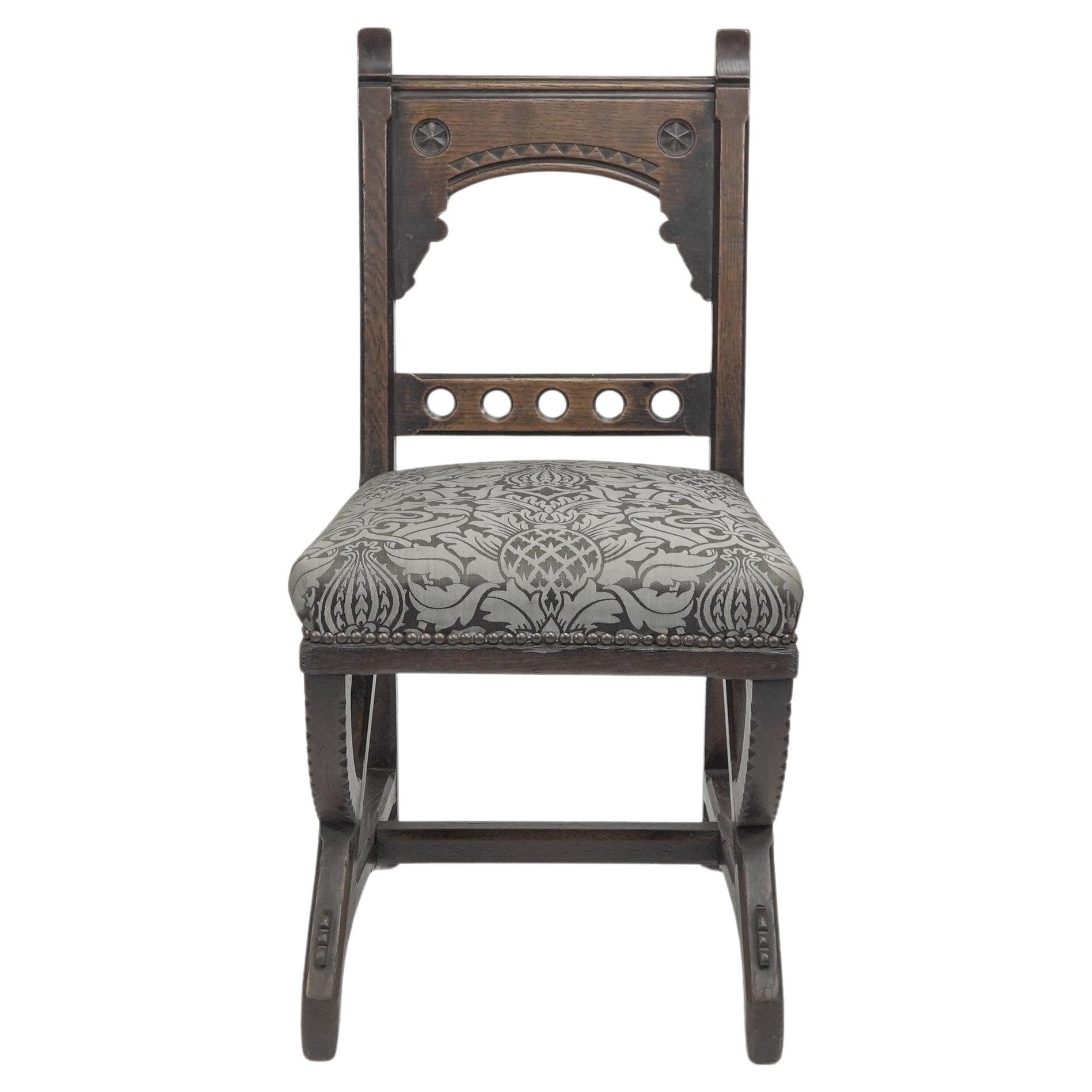 Charles Bevan (attribué), une chaise d'appoint en chêne de style néo-gothique, avec des détails arrondis sur la barre supérieure du dossier, flanquée de montants façonnés avec des bandes en zigzag sculptées et ébonisées sur le dessus, et des détails