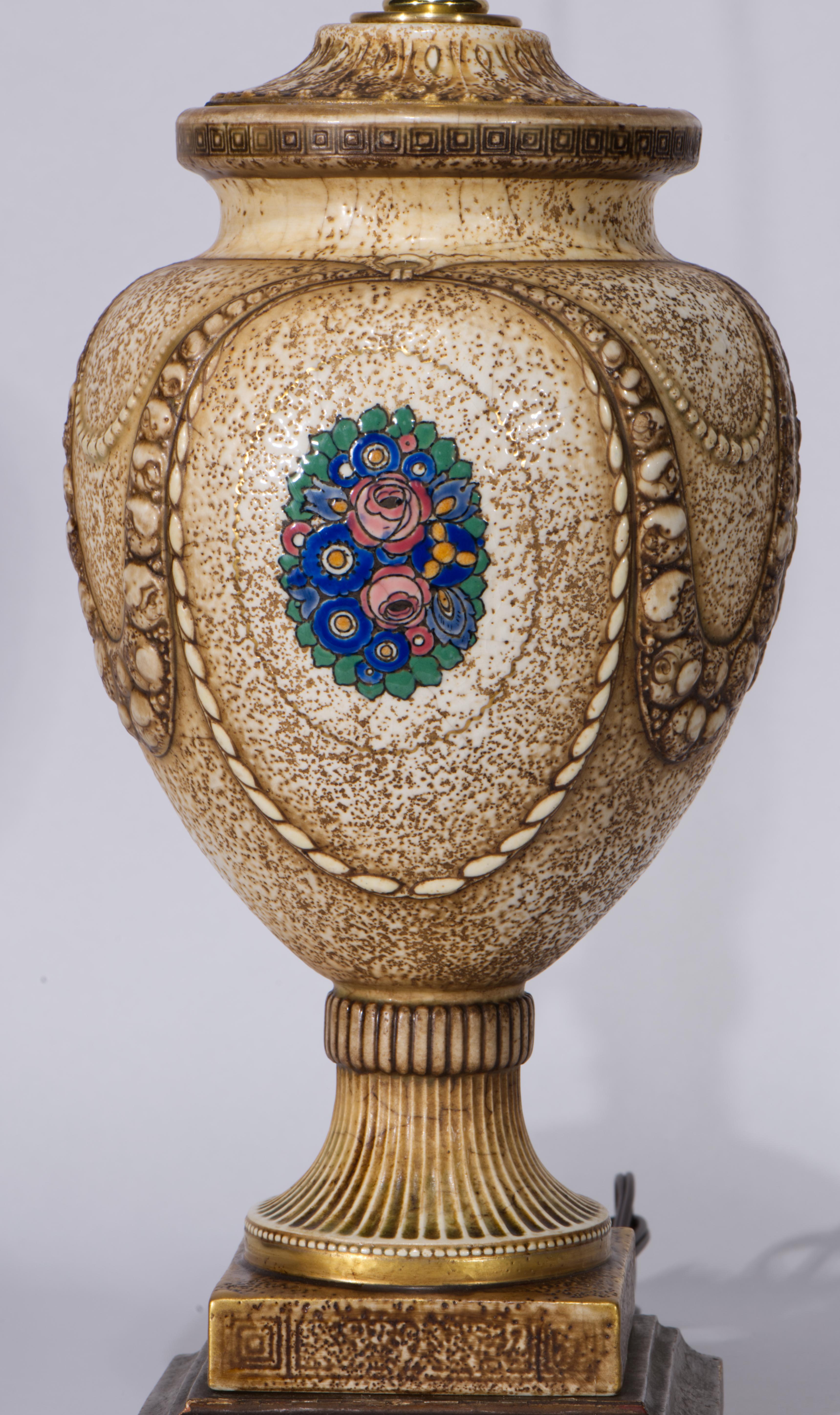  Vintage or antique, rare faience table lamp features an elegant footed urn form with complex relief decor and hand-painted motifs in Art Deco style with orange and yellow flowers and green leaves. This particular design was widely used on various
