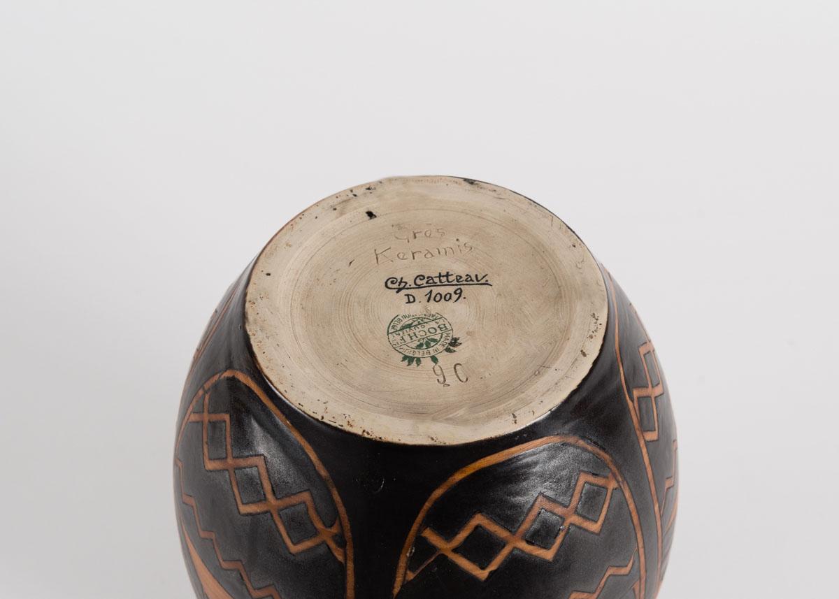 Mit Tinte signiert: Ch. Catteau
Mit Tinte gestempelt: D.1009 (Entwurfsnummer)
Eingeschnitten: Grès Kéramis und 901 (Formnummer)
Gestempelt: Boch F es La Louvière hergestellt in Belgien

Diese Vase trägt das Catteau-Muster D.1009 mit Vögeln vor